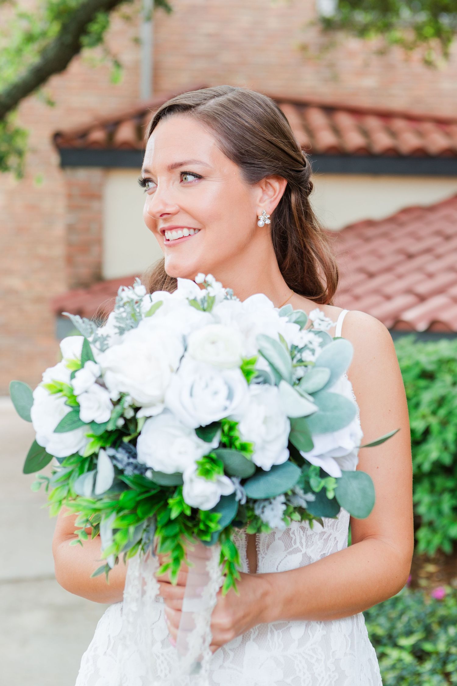 Wedding bouquet details featuring white roses and eucalyptus leaves.