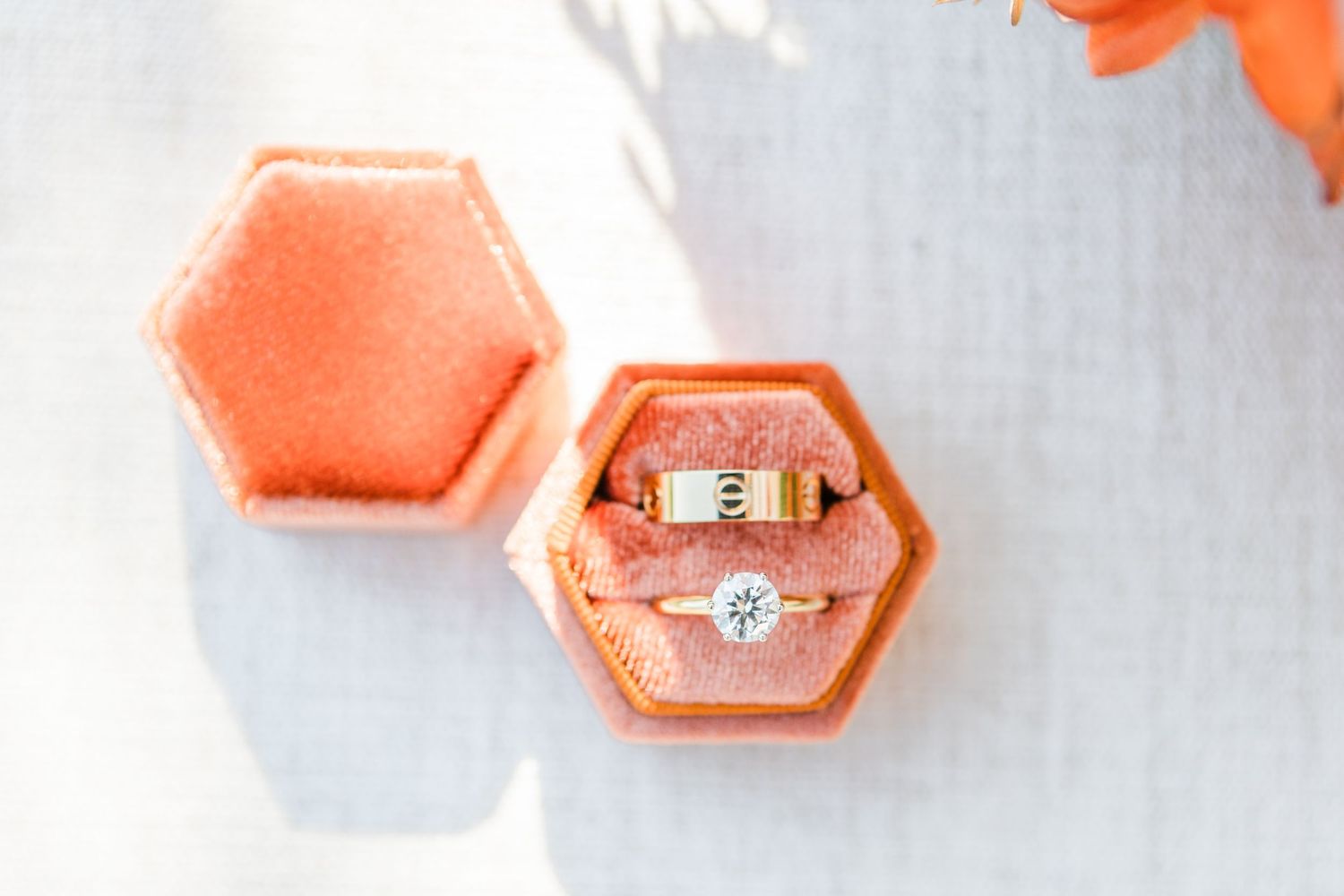 Small hexagonal pink ring dishes with gold accents are arranged in a minimalist display against a light background.