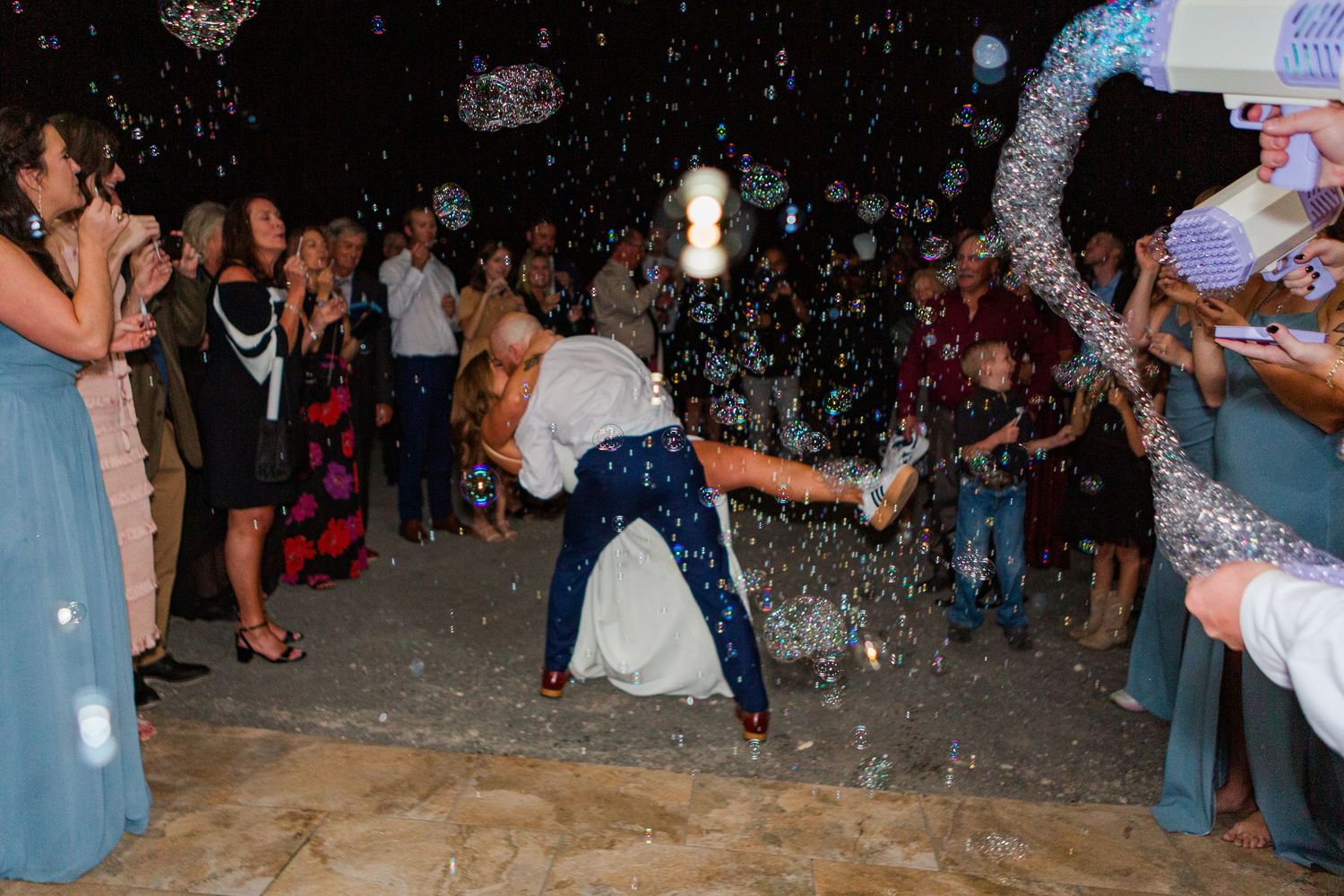 Sparkles and confetti shower over wedding party members during an indoor celebration.