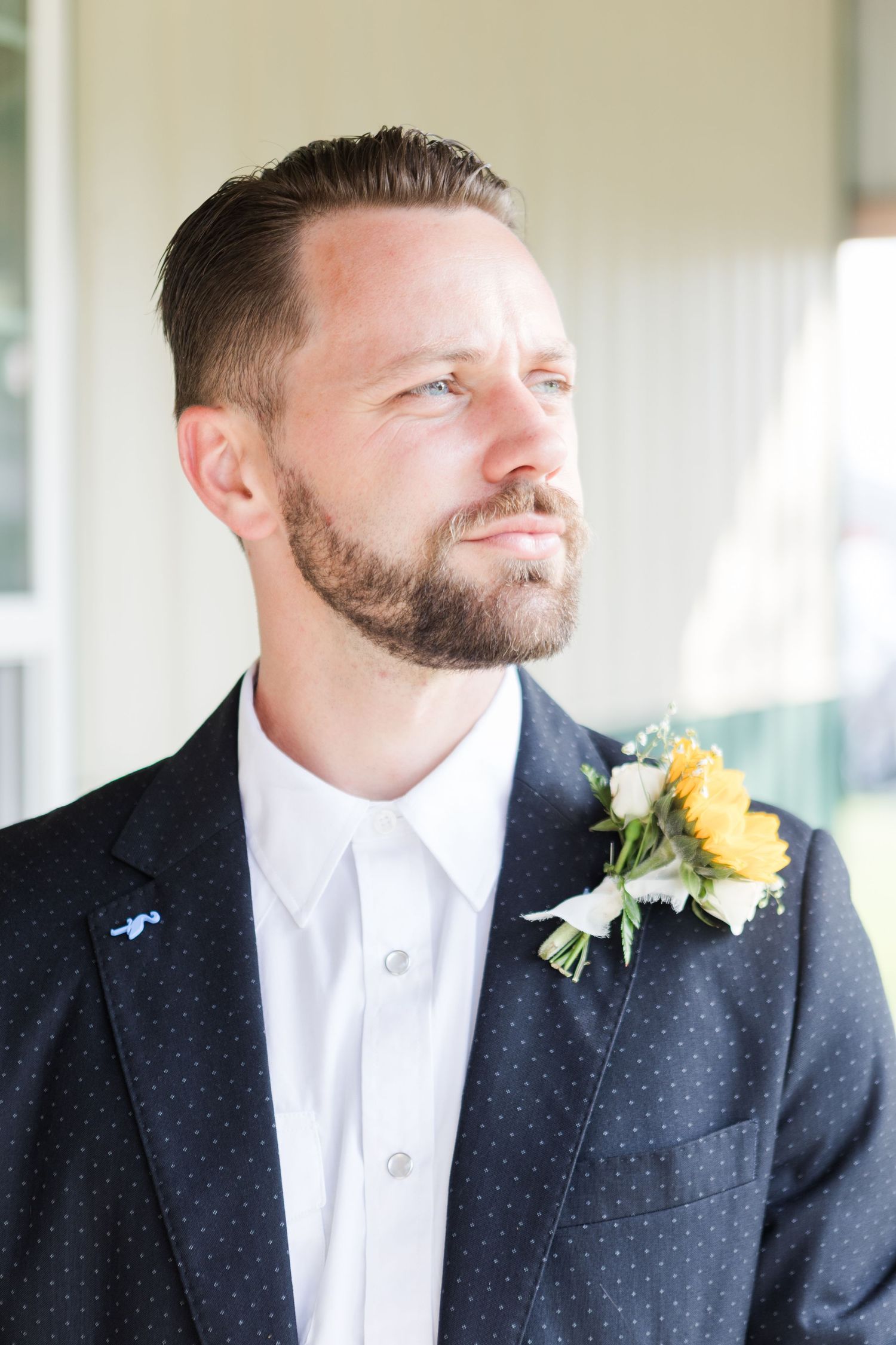 Portrait series of groom wearing navy suit with yellow sunflower boutonniere.