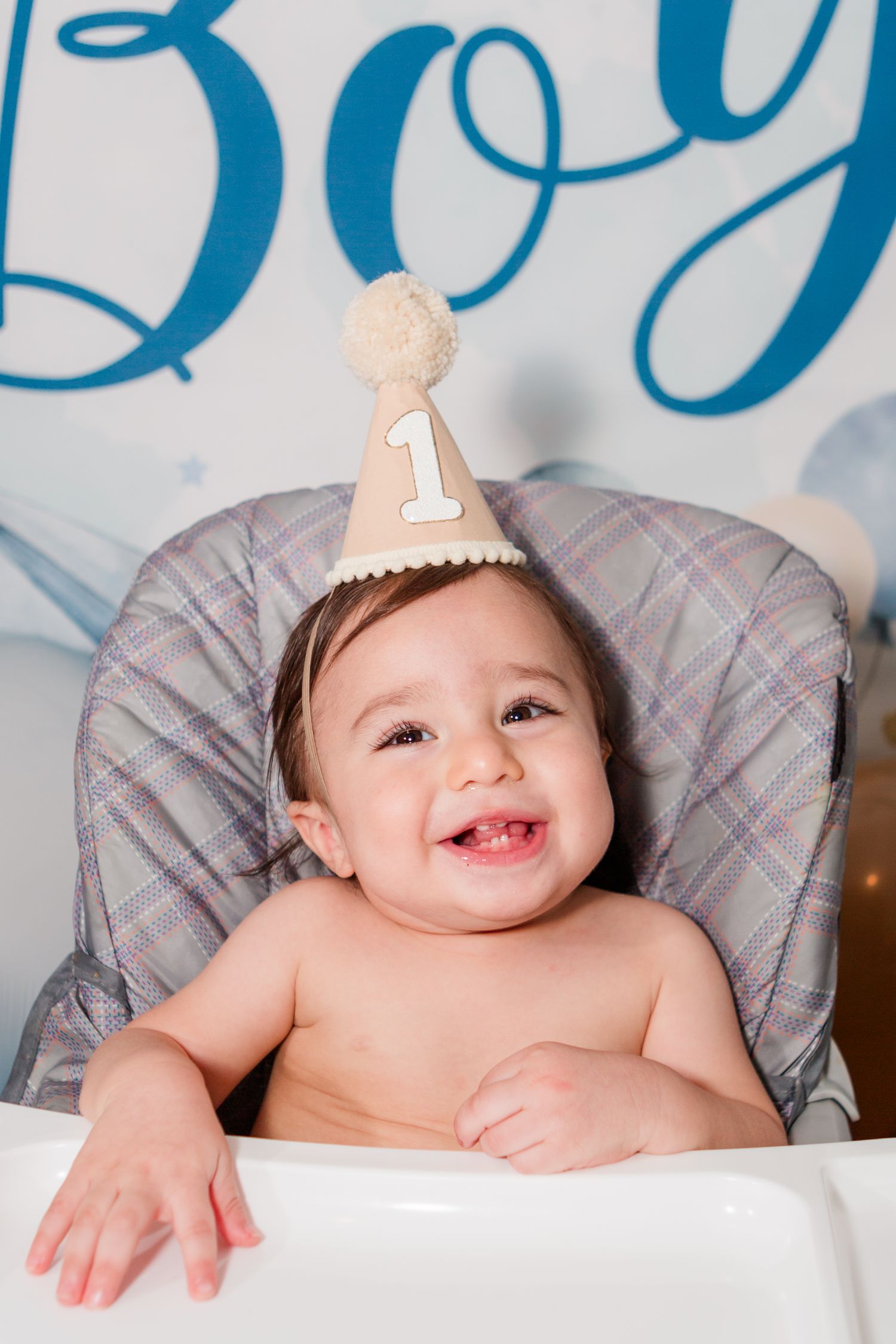 First birthday celebration setup with blue decorations and high chair.