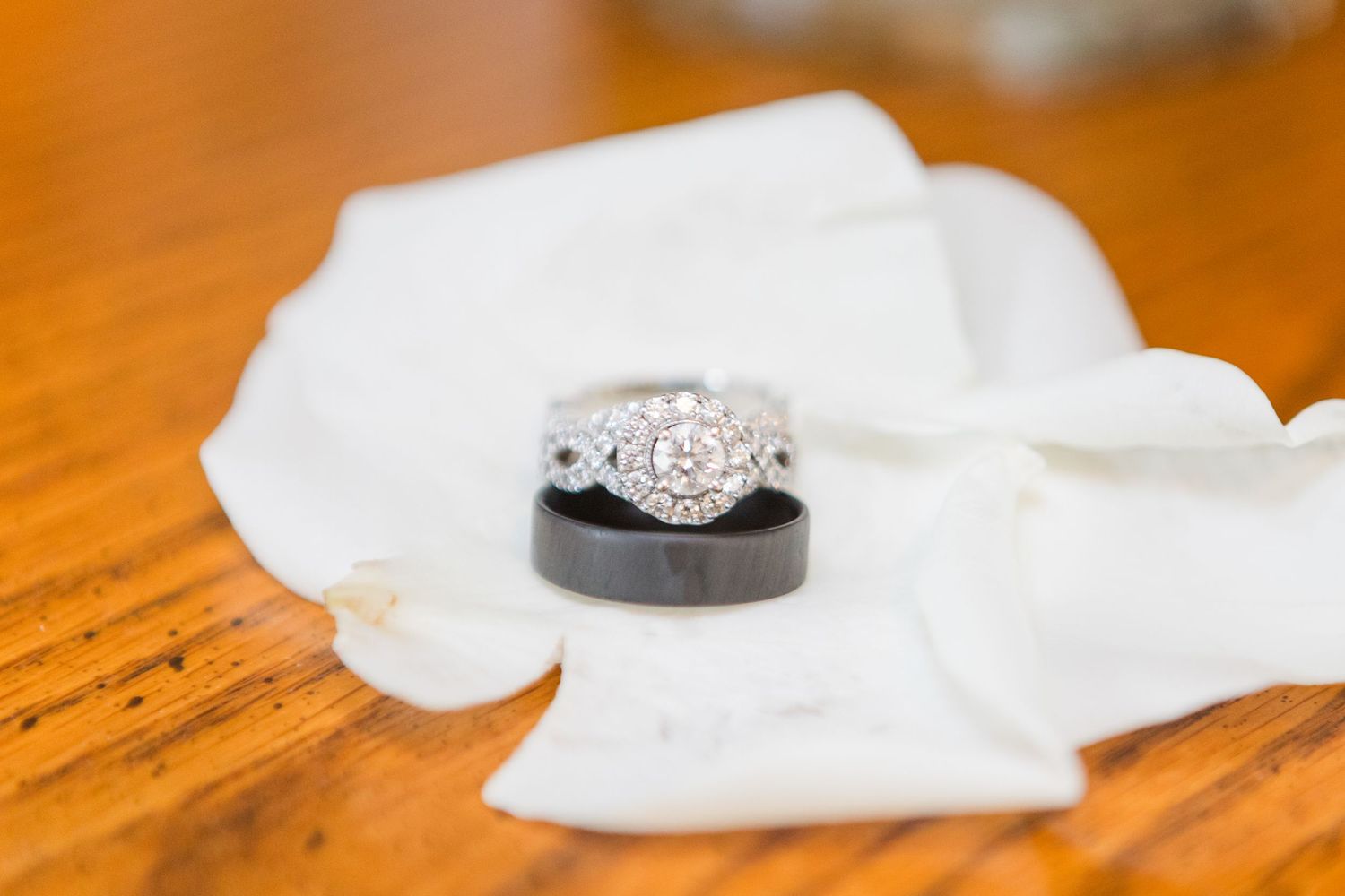 Wedding rings and bands displayed on polished wooden surface.