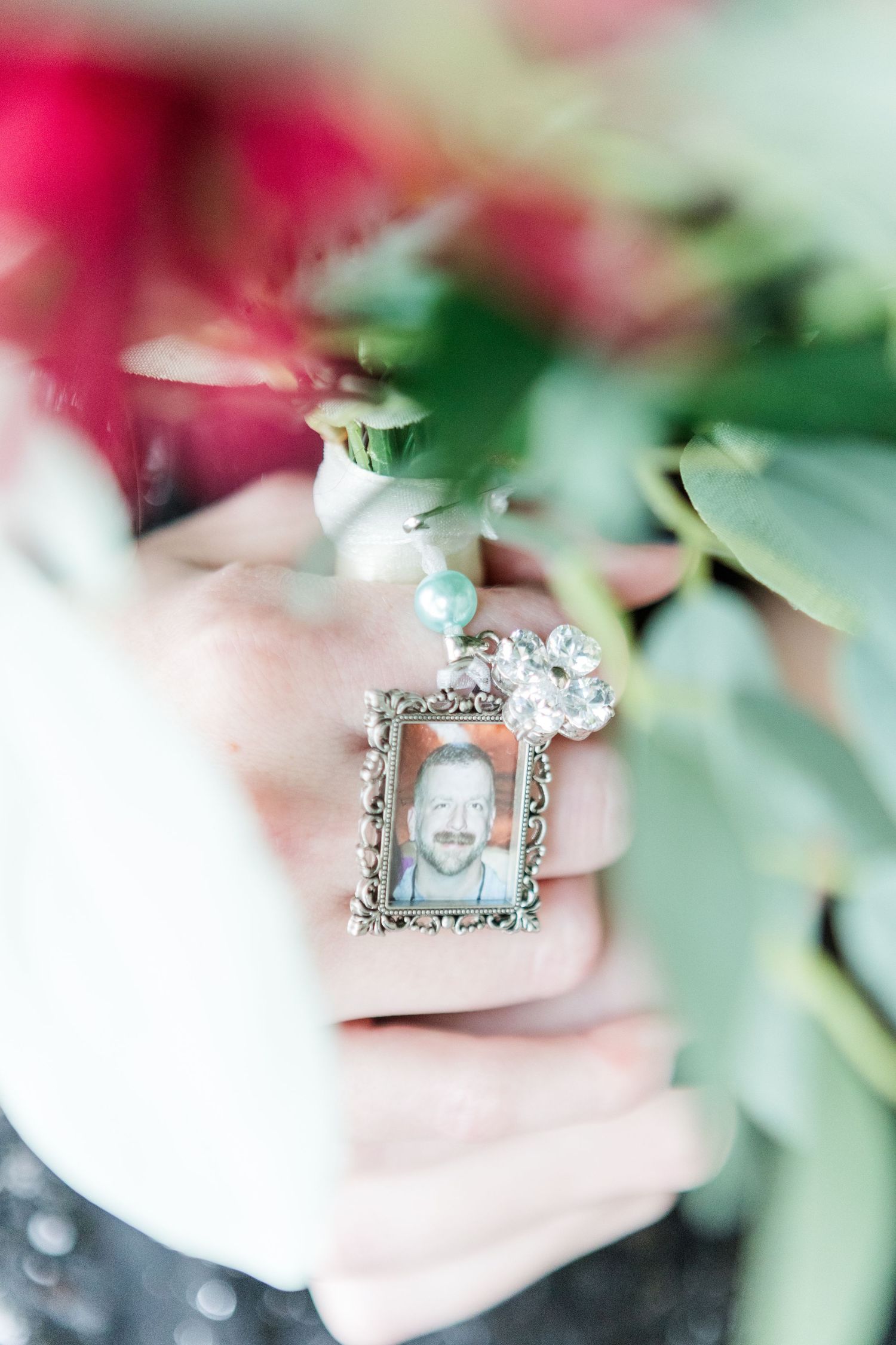 Close-up of a sparkling ring with diamonds and detailed metalwork against soft floral background.
