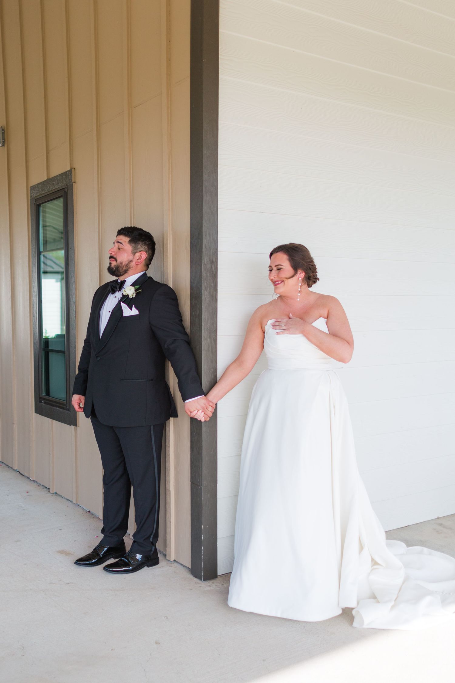 Couple shares intimate moment during first look wedding photos while holding hands.