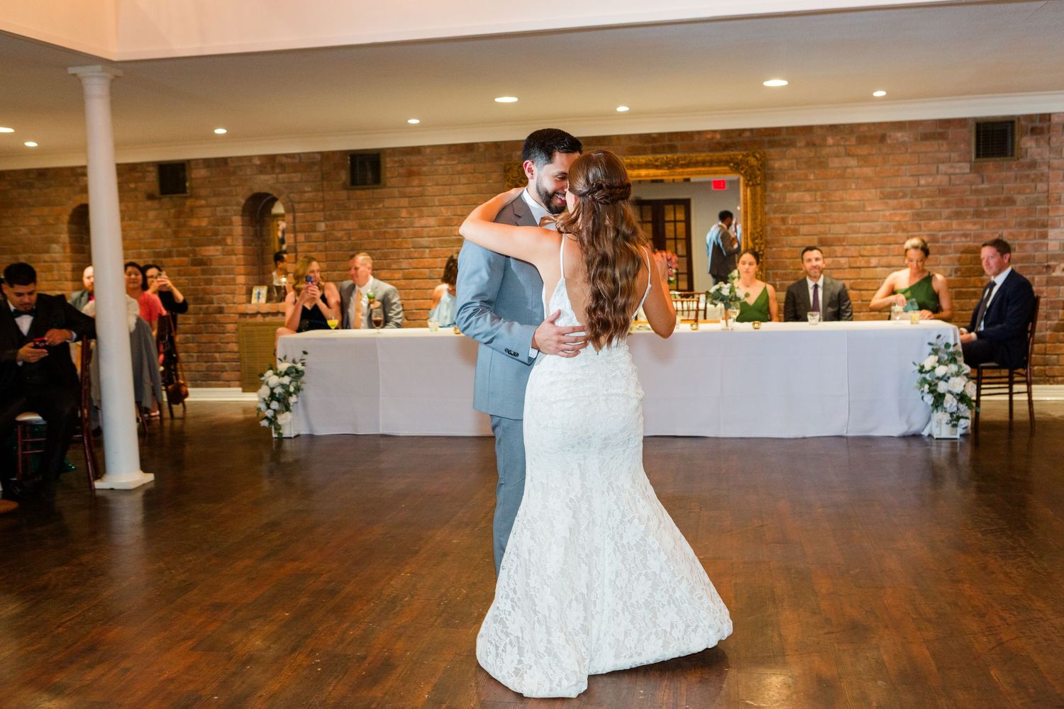 Wedding reception panorama showing dancing couples on hardwood floor.