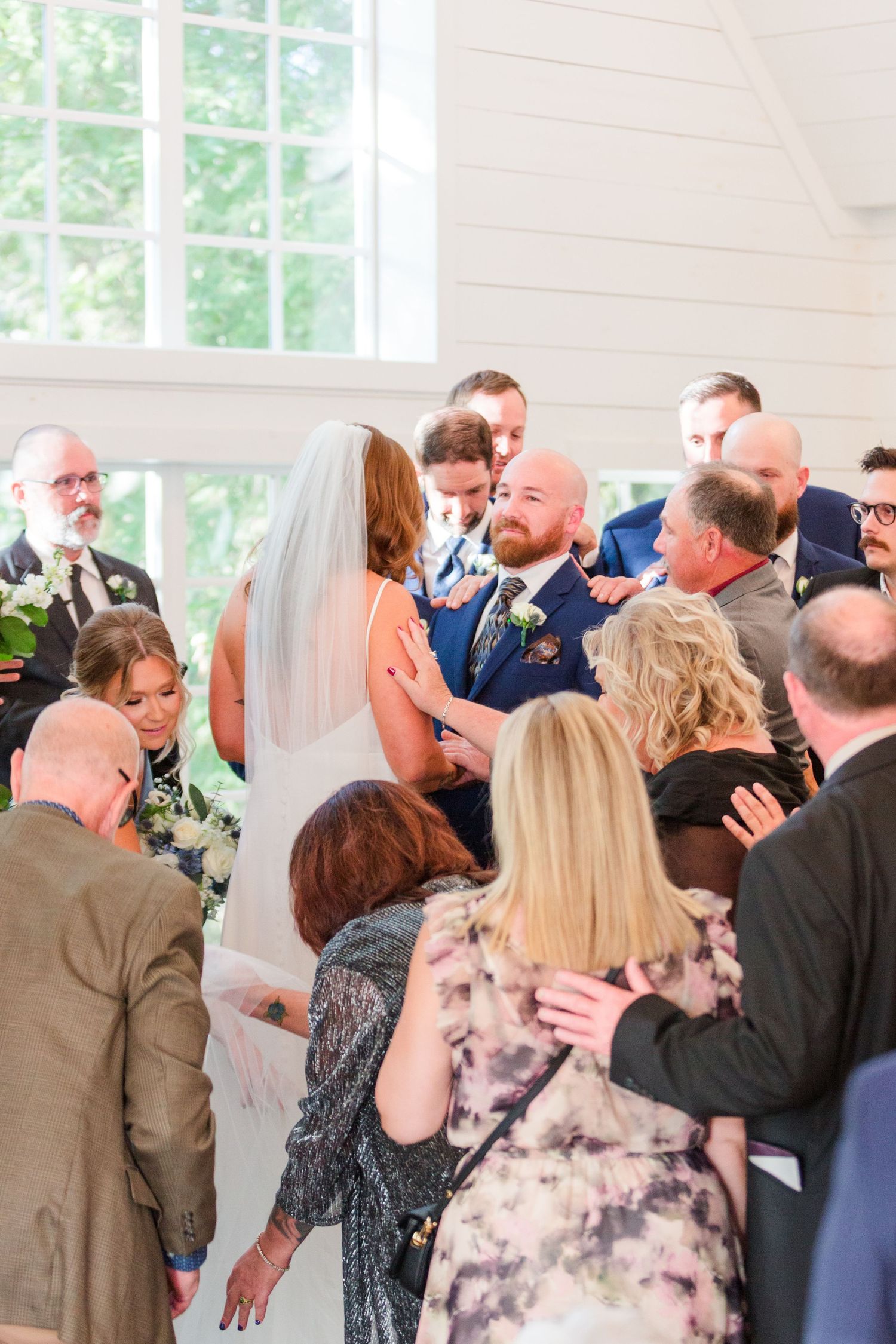 Wedding ceremony crowd gathered around couple during intimate moment.