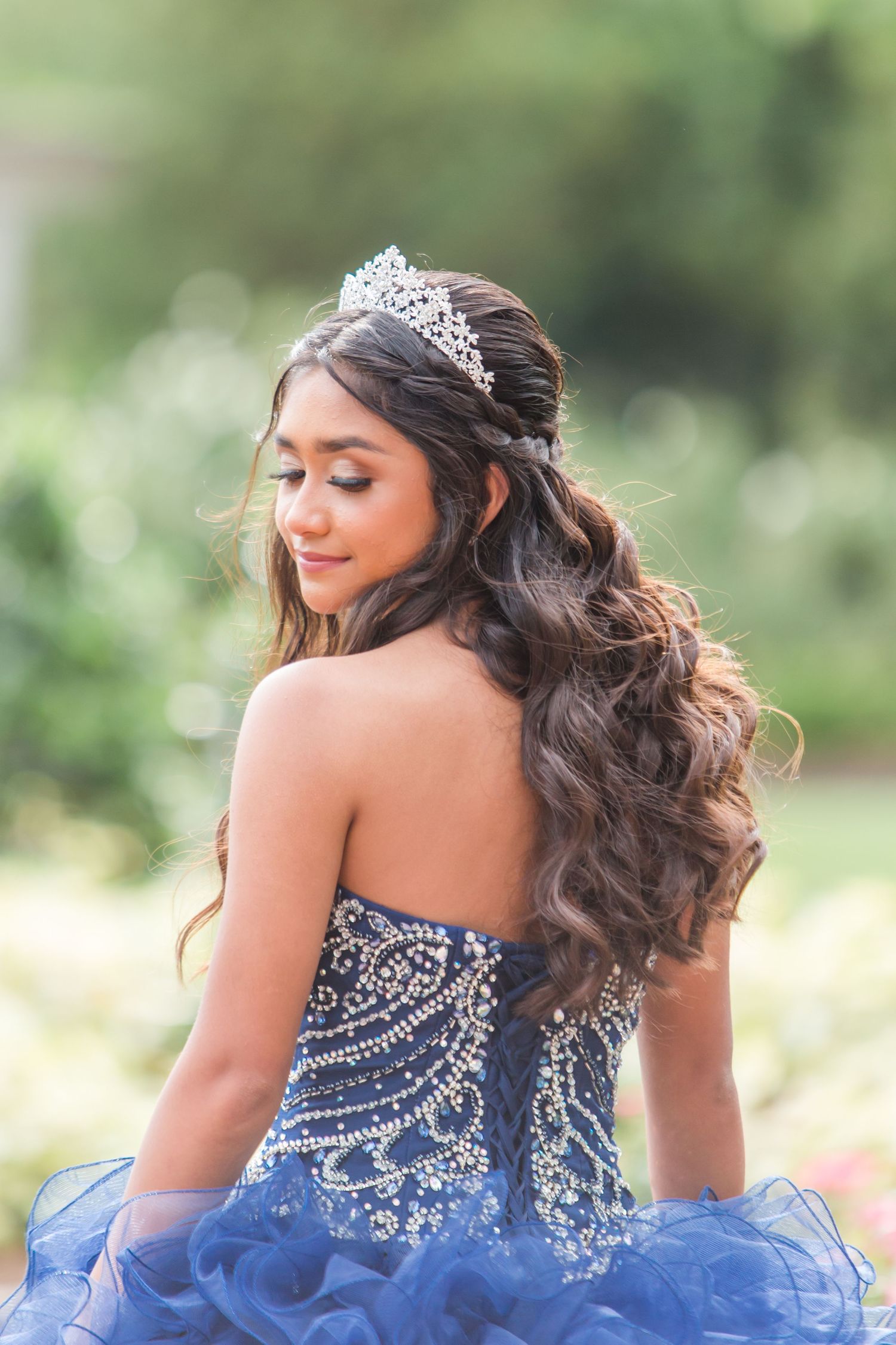 Sparkly beaded blue ball gown shown from behind with intricate crystal details.
