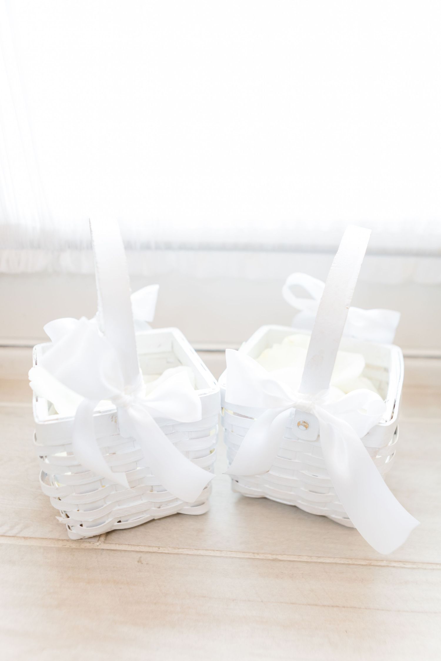 White decorative ribbons arranged on a light wooden surface.
