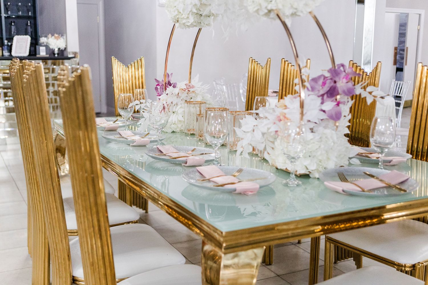 Opulent banquet hall with gold chairs and ornate table settings featuring crystal decor.