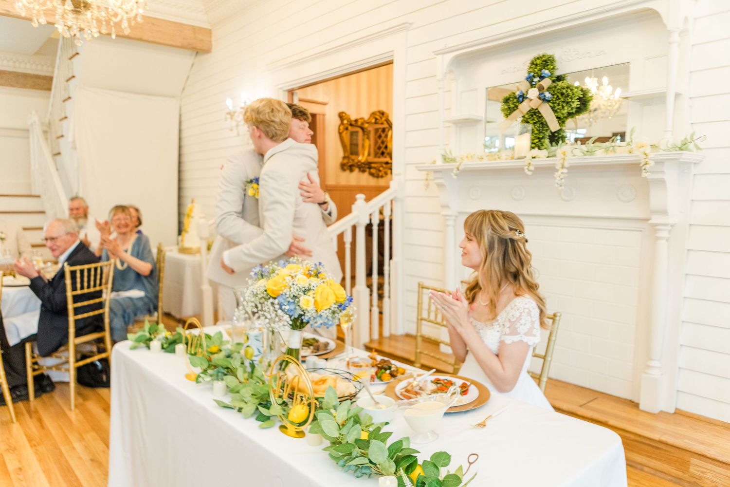 Bright reception hall with floral centerpieces and white walls.