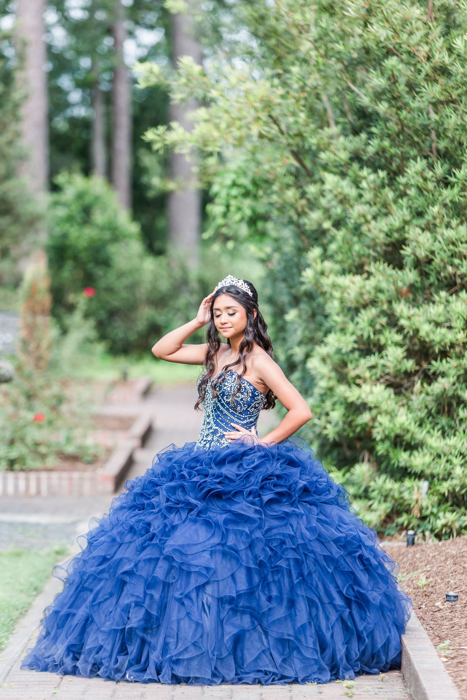 Flowing royal blue ball gown captured in multiple poses in a garden setting.