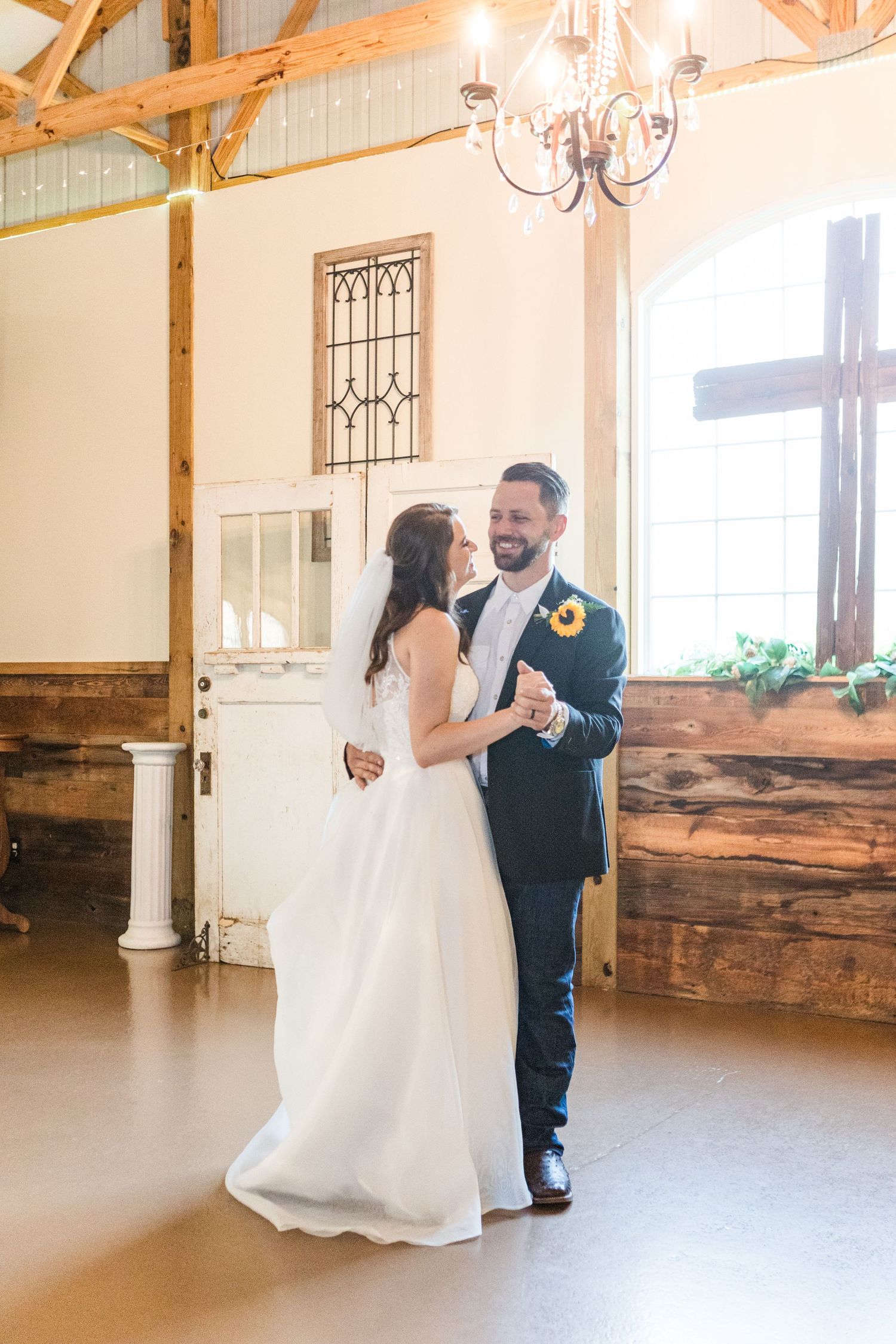 Elegant dance moves displayed in a barn-style reception venue with wooden accents.