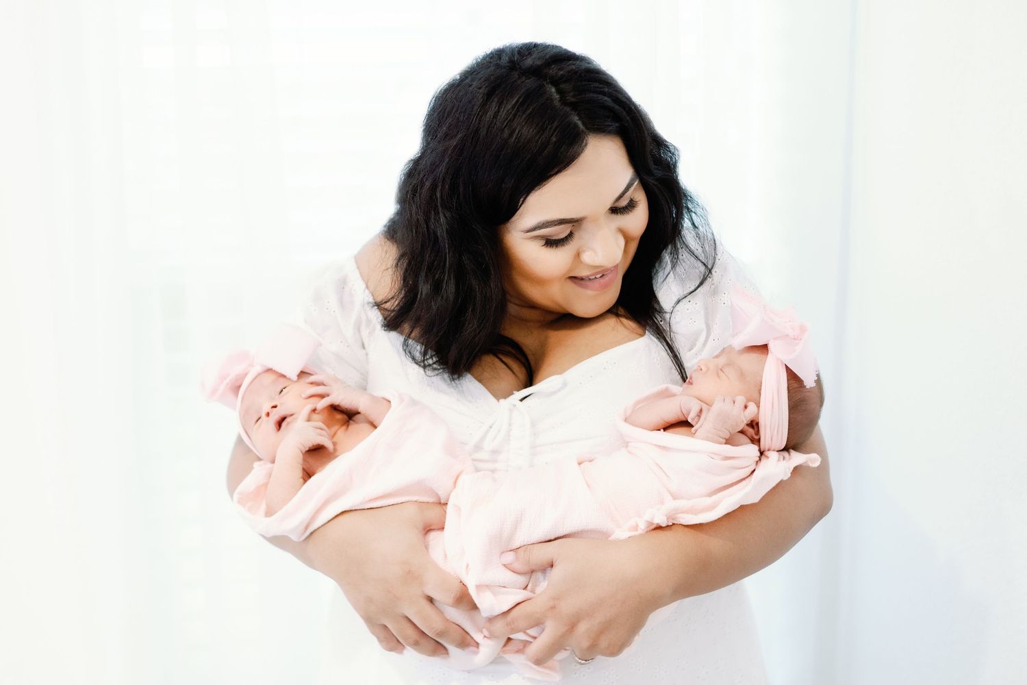 A series of tender maternal photographs in soft pink tones showing a mother cradling her newborn.