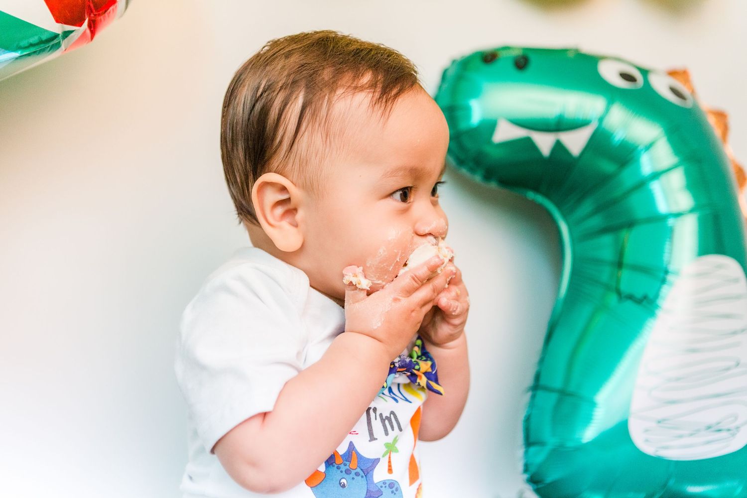 Birthday celebration with teal dinosaur balloons and party decorations.