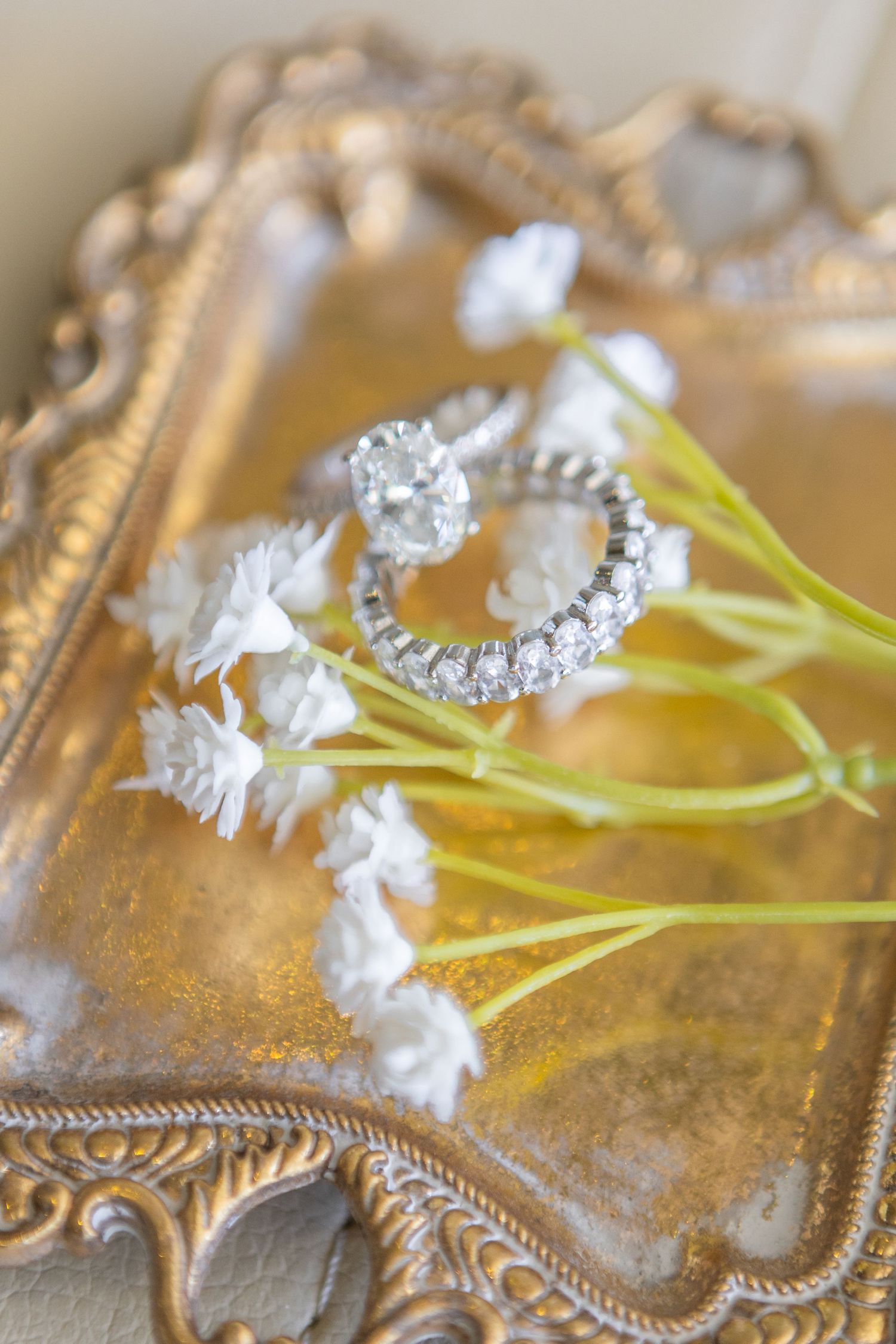 Decorative gold tray with small white flowers and elegant details.