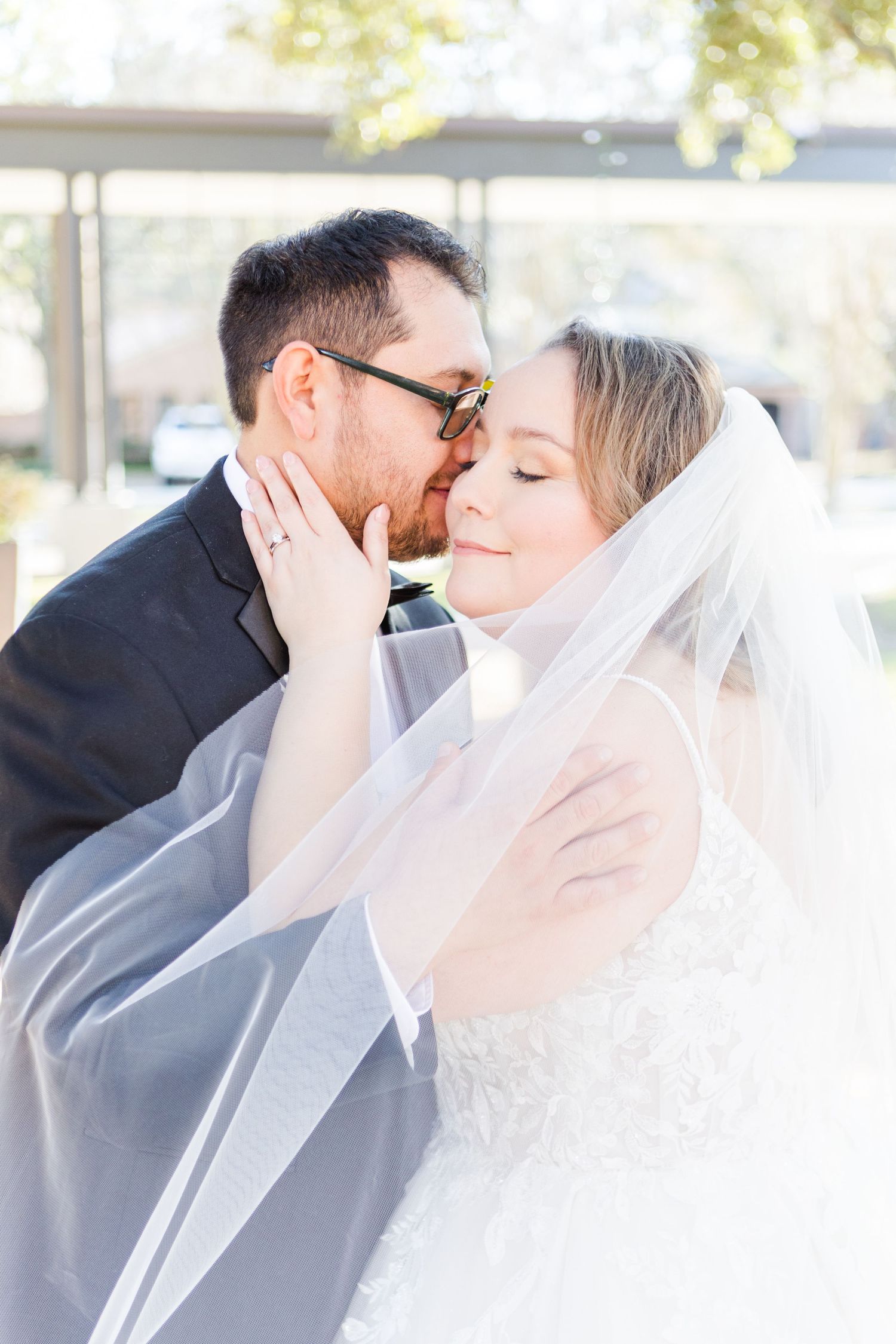 Sun-drenched wedding portraits capturing tender moments between newlyweds.
