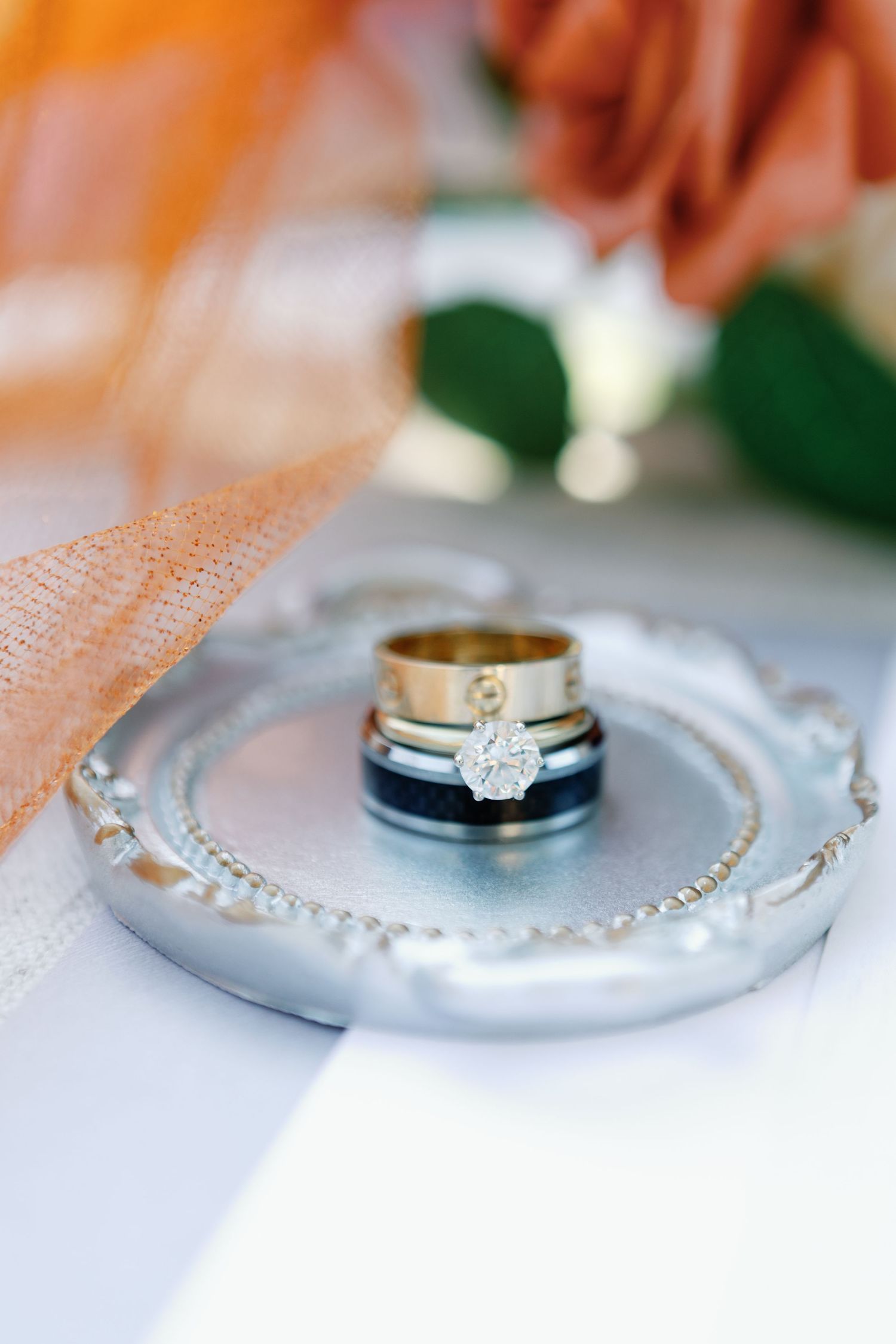 Close-up shots of elegant wedding rings and diamond jewelry displayed on a light surface with soft lighting.