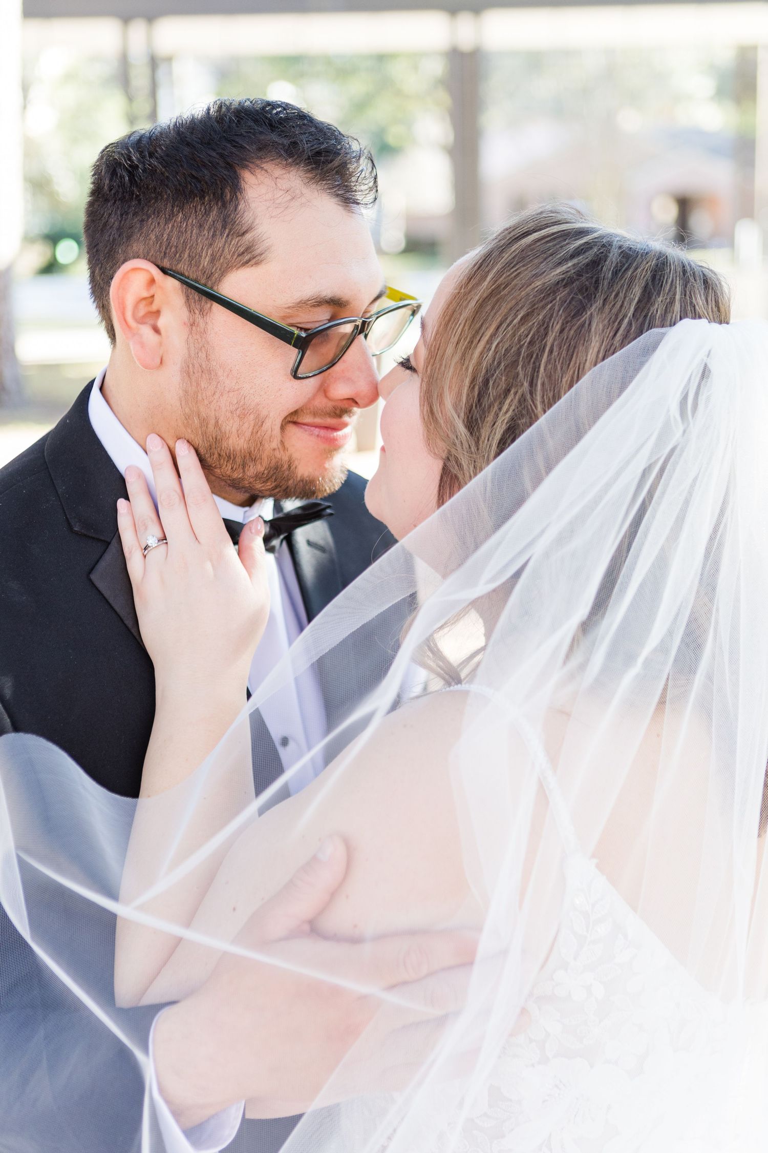 Soft and ethereal wedding photos showing tender moments through a delicate white veil.