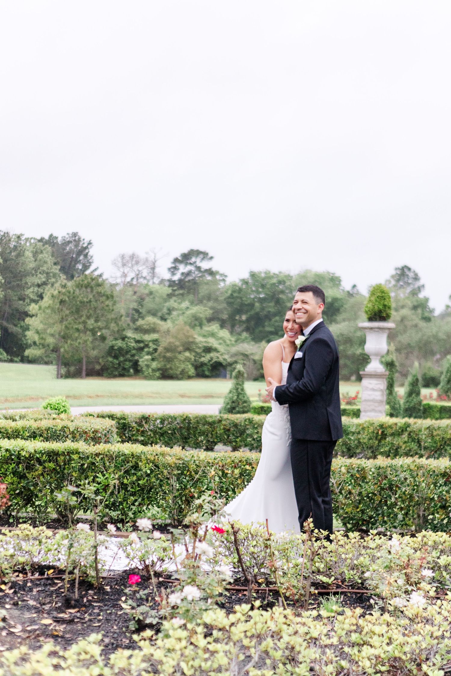Joyful moment captured in a formal garden setting with blooming flowers.