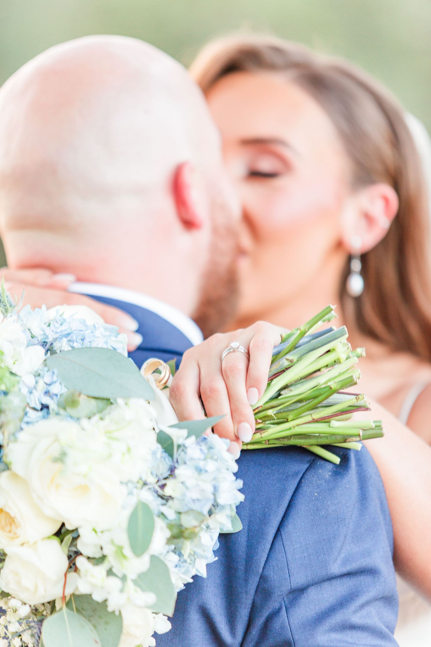 Close-up of romantic moment with blue hydrangea bouquet in soft natural light.