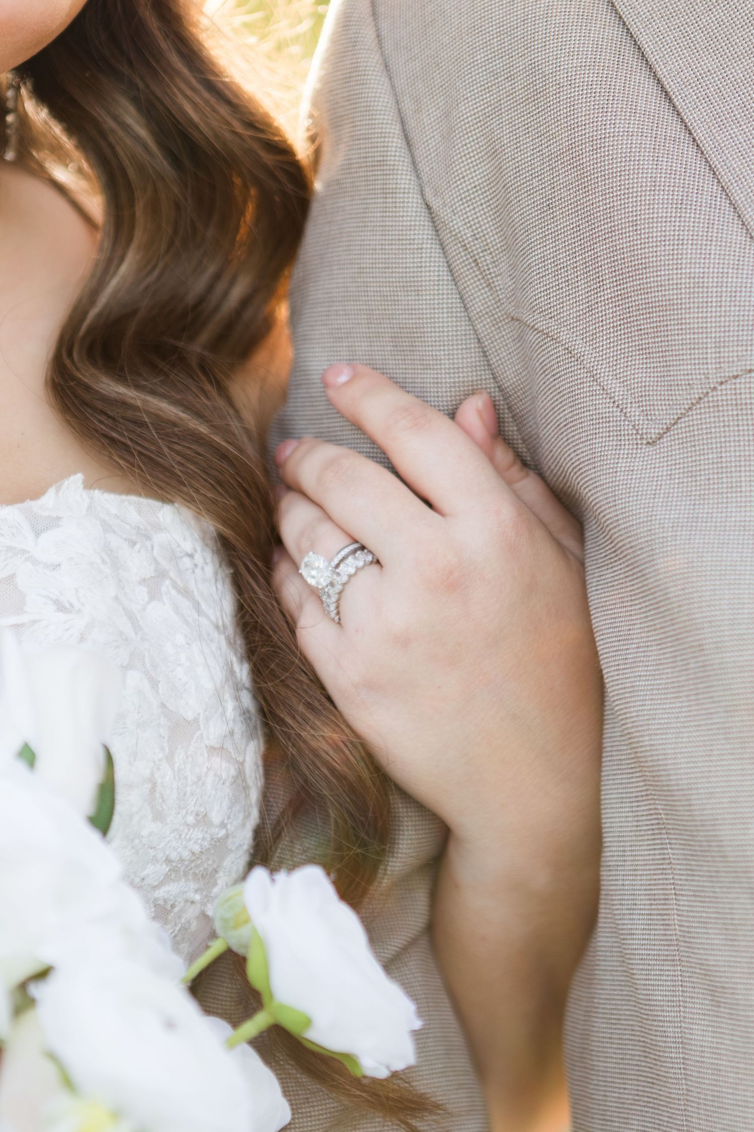 A romantic couple shares tender moments wearing white lace and western attire.