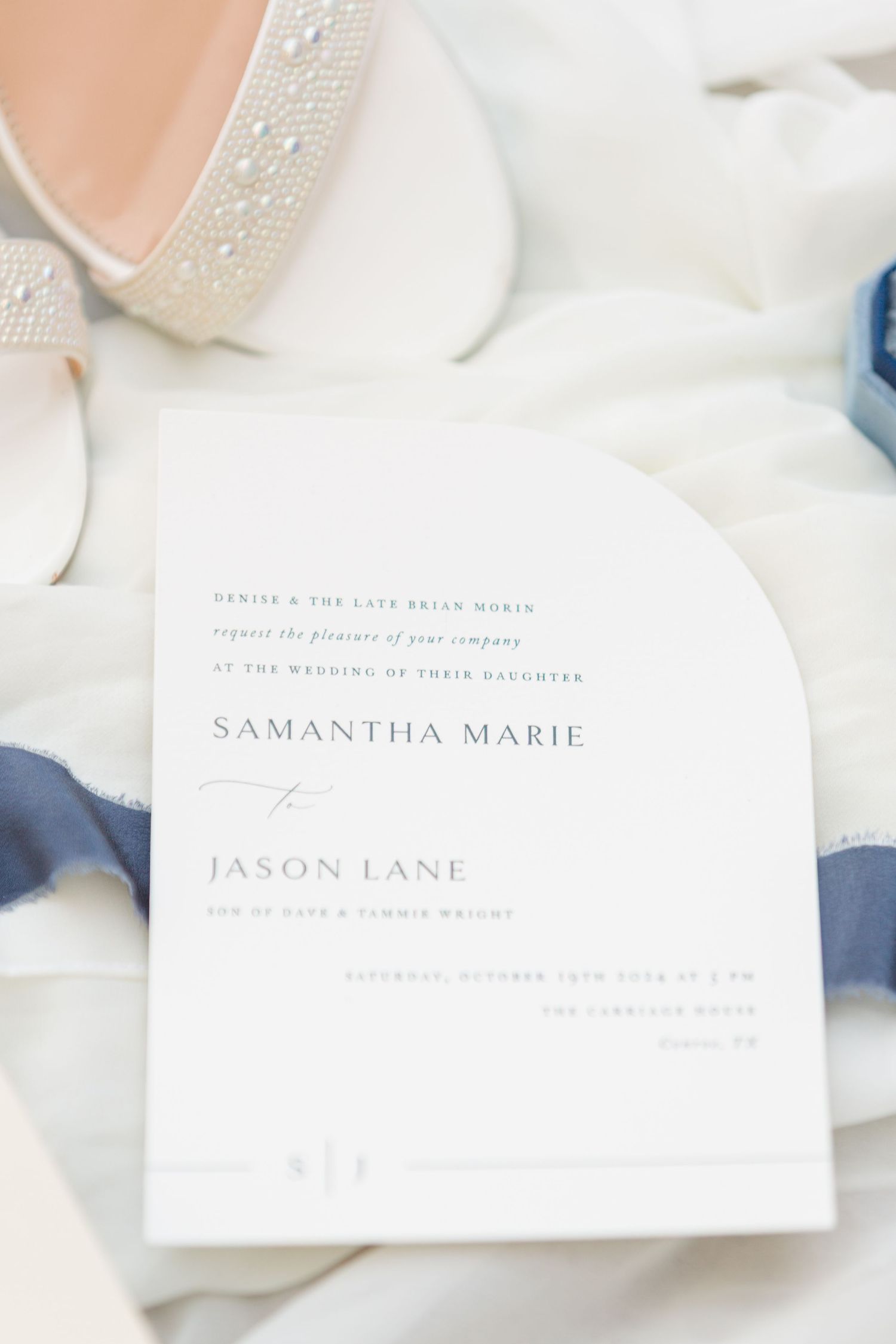 Elegant wedding invitation with minimalist typography design on white paper.