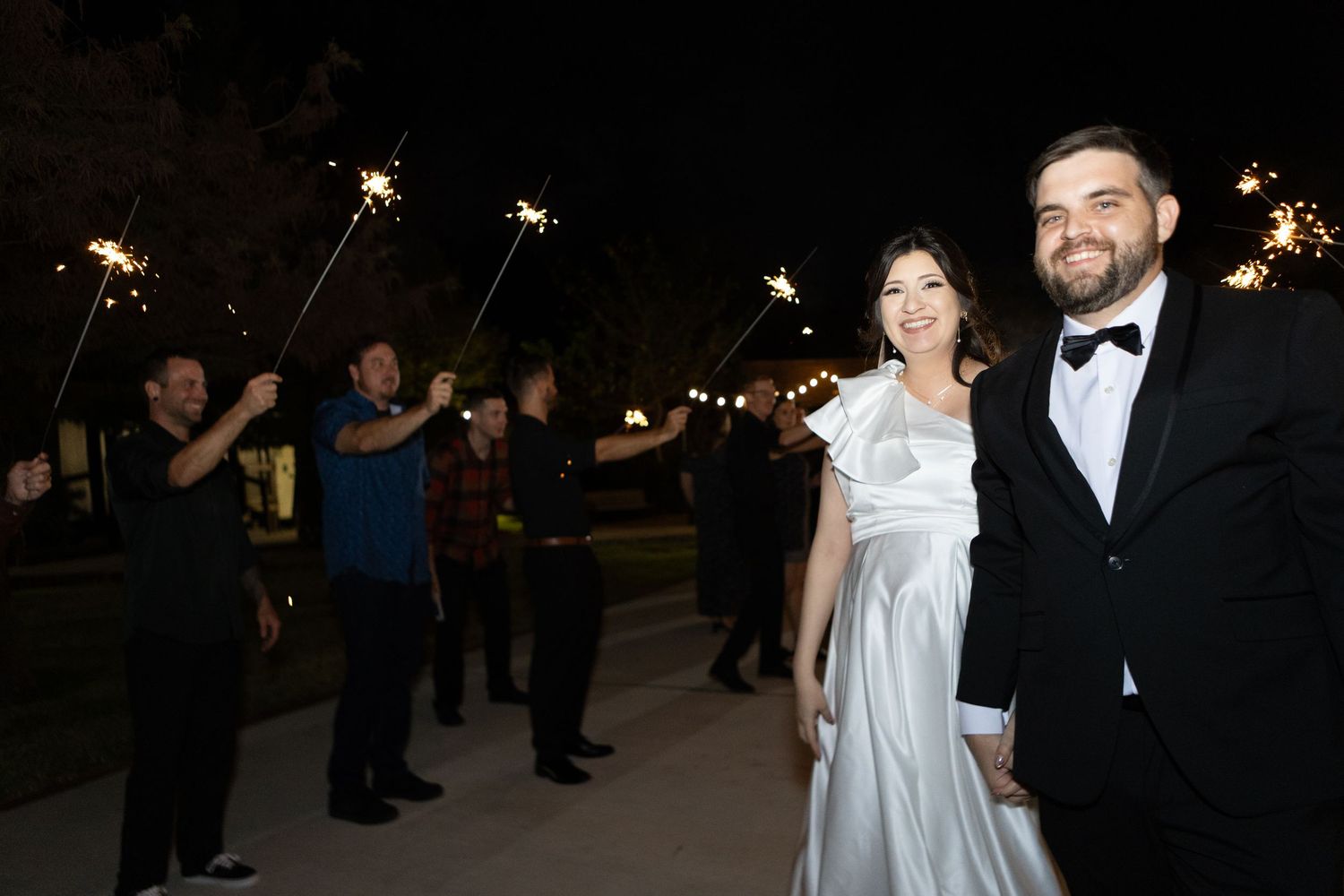 Nighttime wedding celebration with sparklers creating romantic atmosphere.