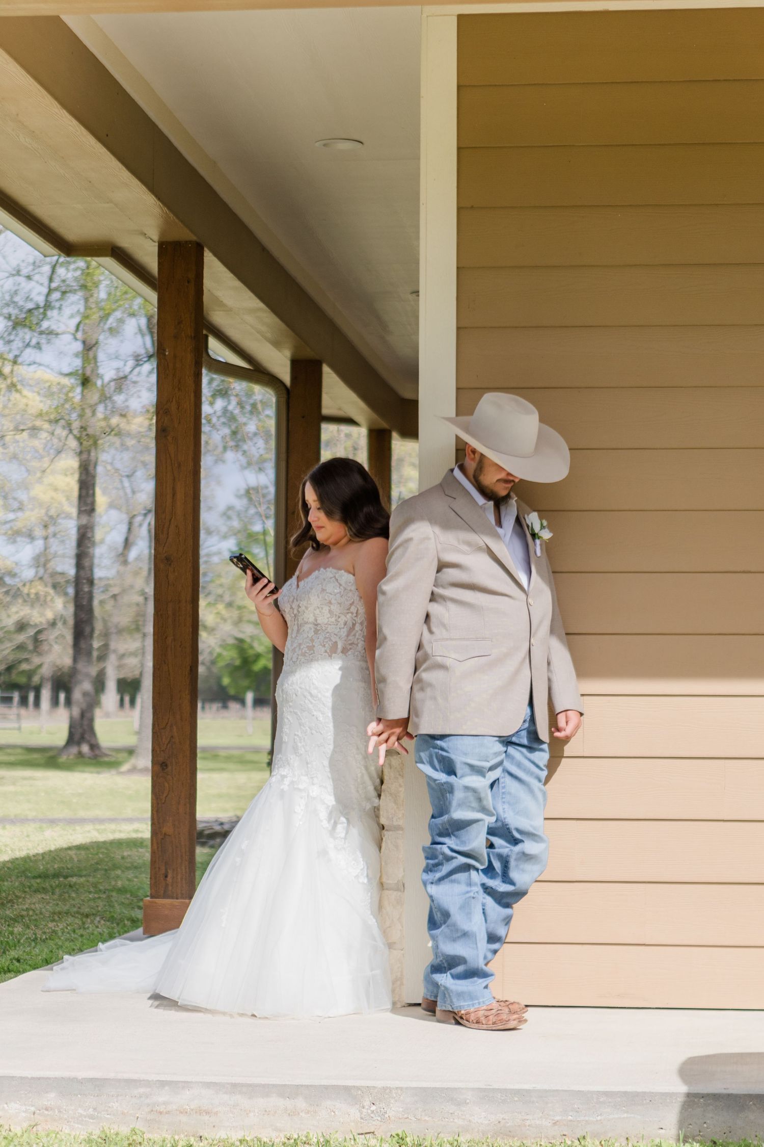 Couple sharing a private moment around a corner on a covered porch before their wedding.
