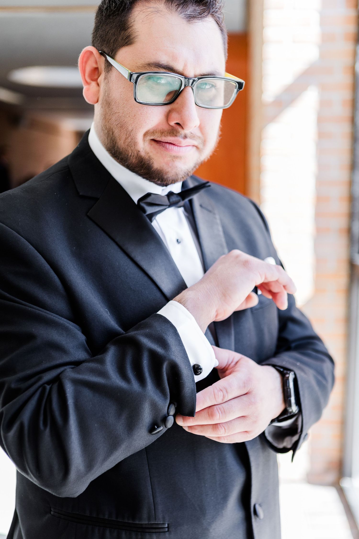 Person in formal attire making final adjustments to their outfit.