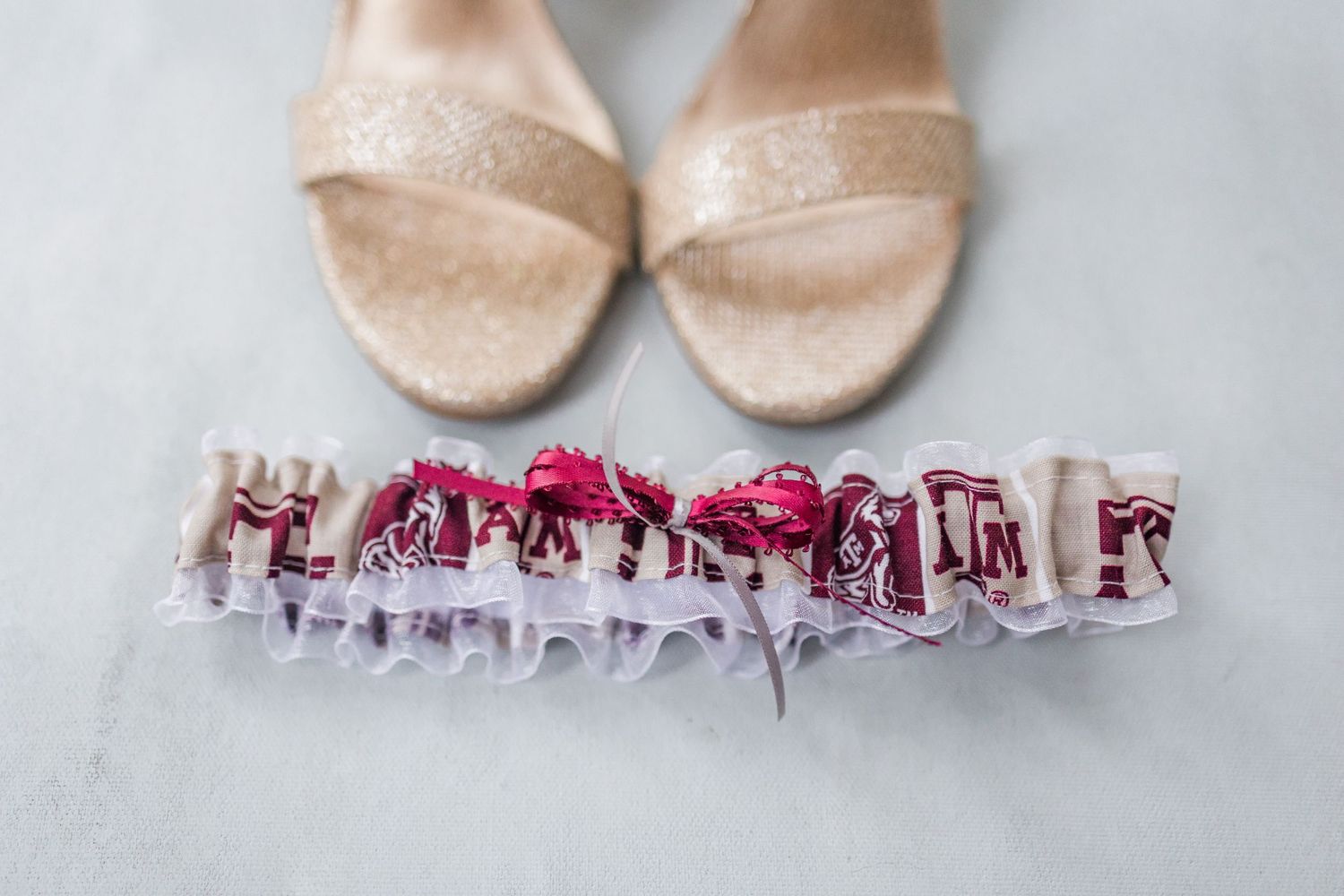 Collection of bridal garters in pink and white lace displayed on light gray background.