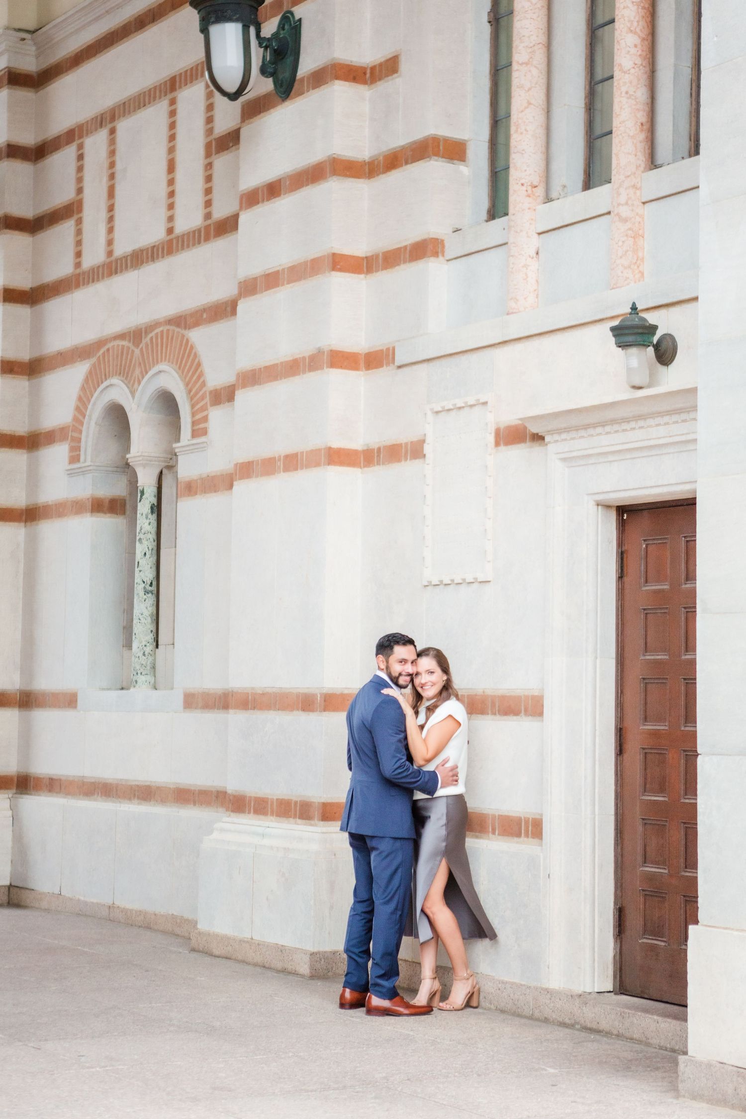 Romantic photo session under classic arched walkway with decorative brick details.