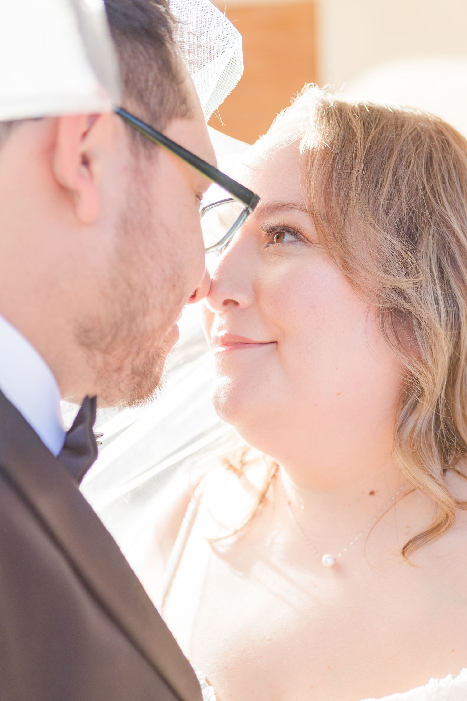 Soft sunlit profile portraits capturing intimate wedding day moments.