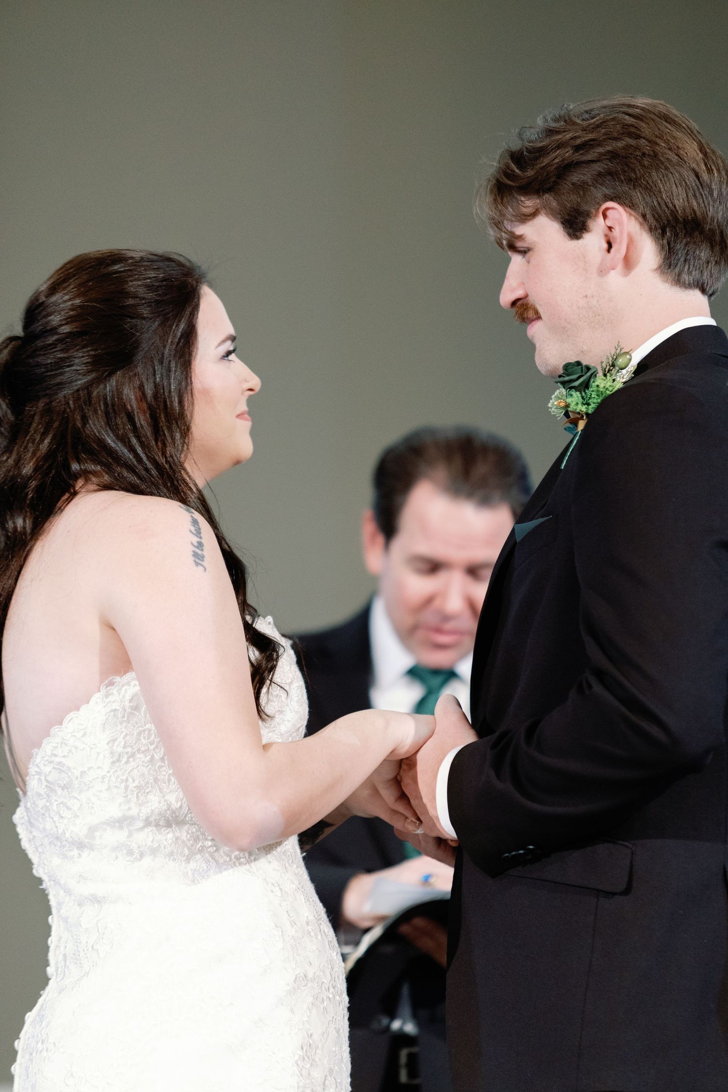 Wedding ceremony moment captured in soft lighting with formal attire.