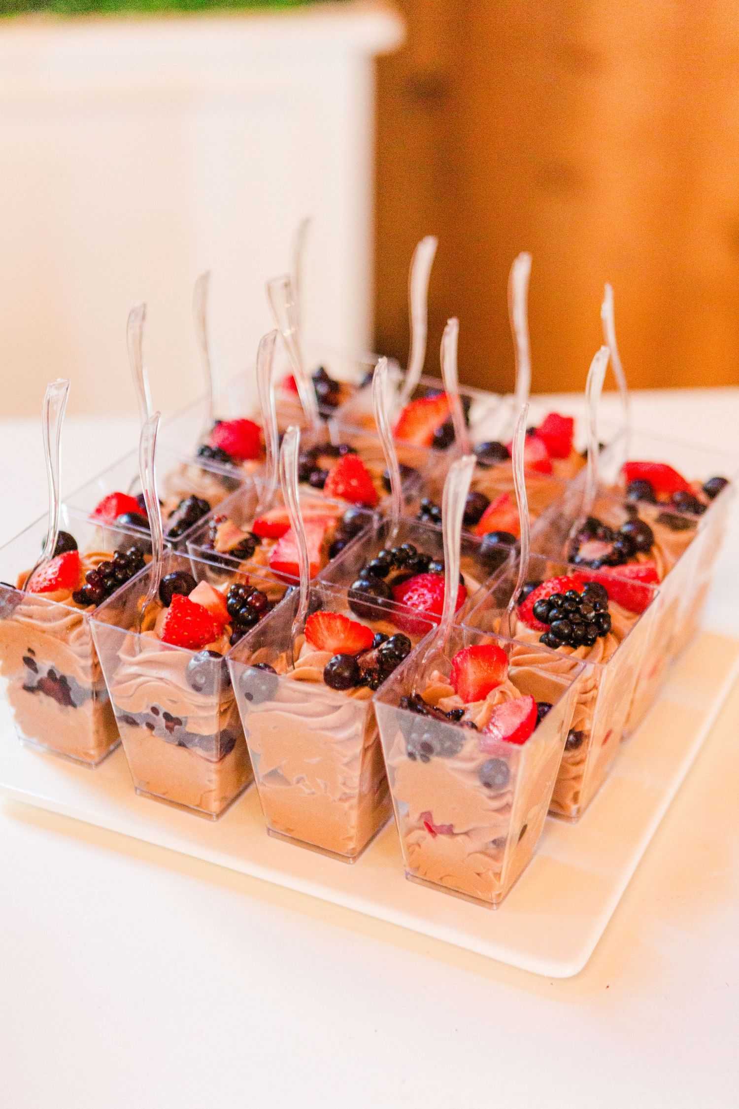 Chocolate mousse dessert cups garnished with fresh berries and mint served at wedding reception.