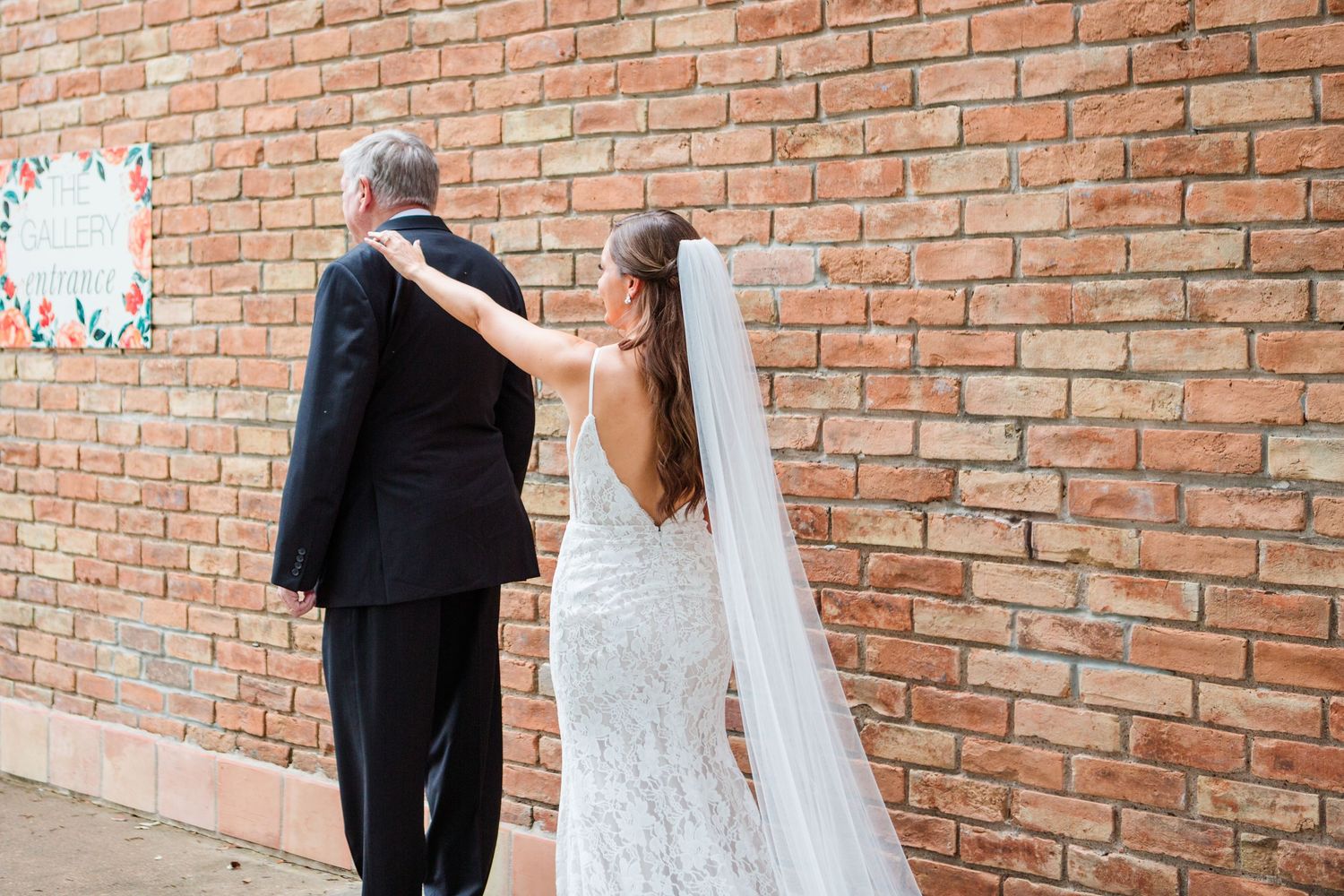 Wedding couple sharing intimate moments against industrial brick backdrop.