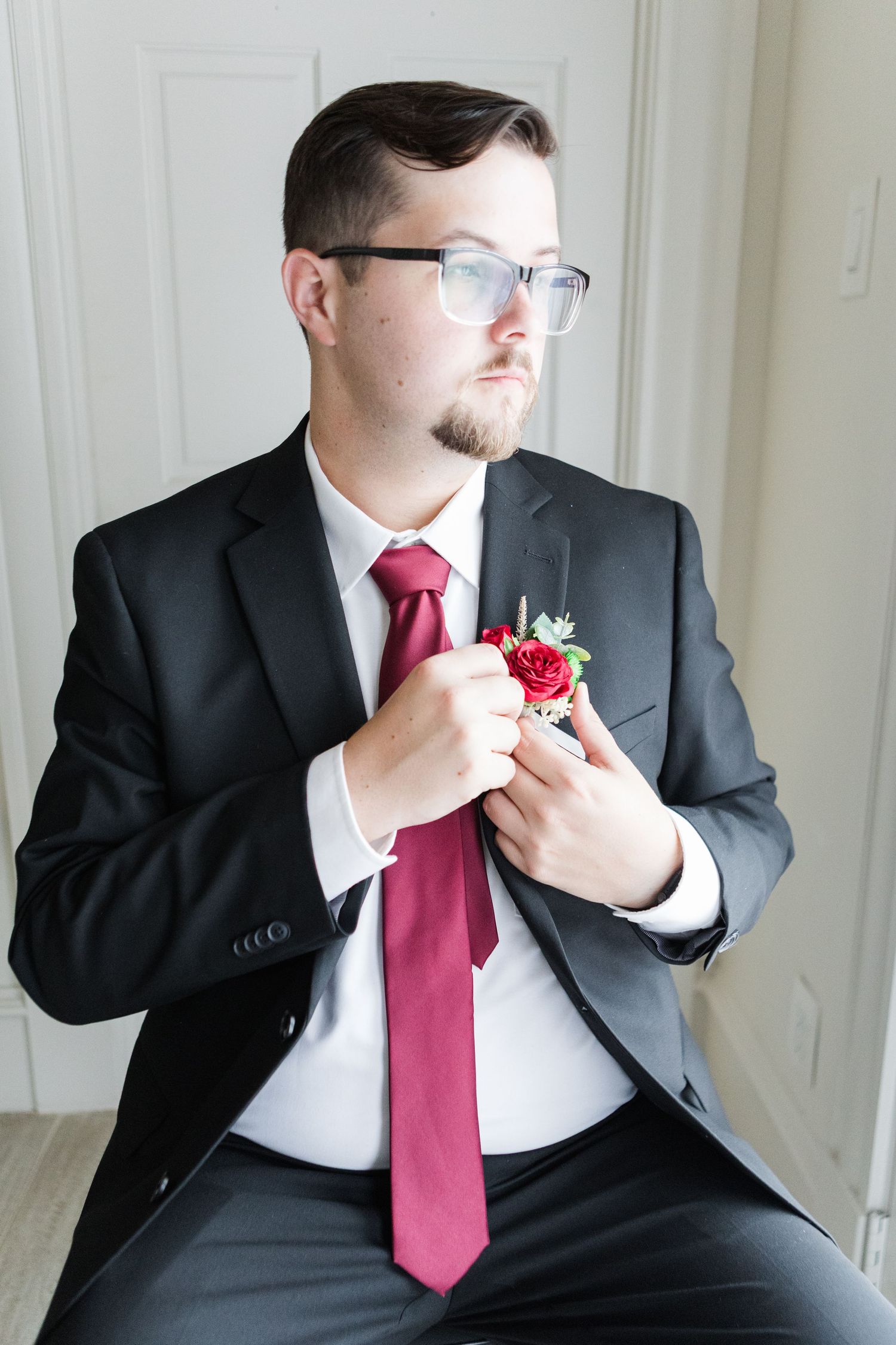 Wedding day portrait series showing groom in formal attire with red boutonniere.