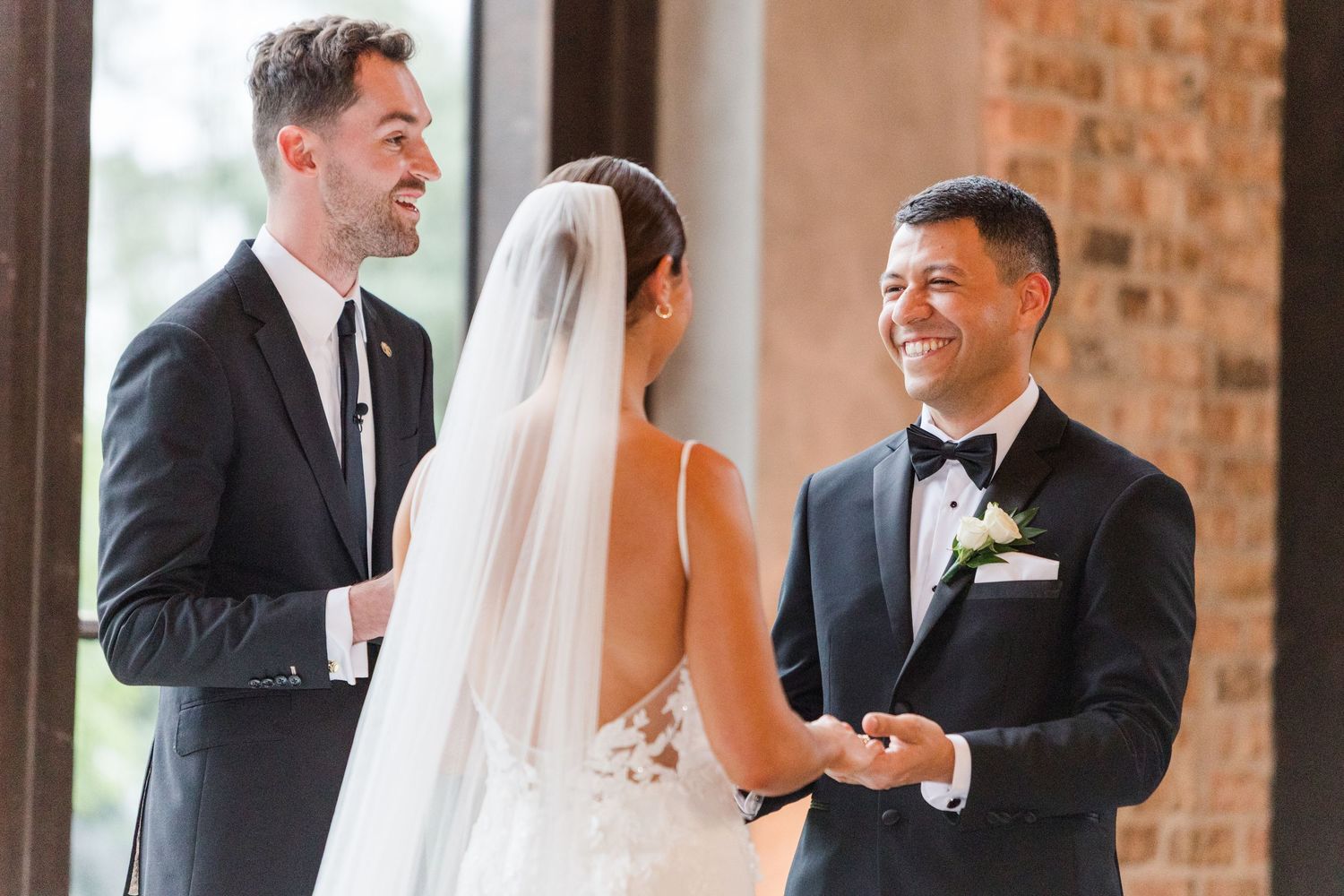 A touching exchange between a couple during their wedding vows beside elegant white floral decorations.