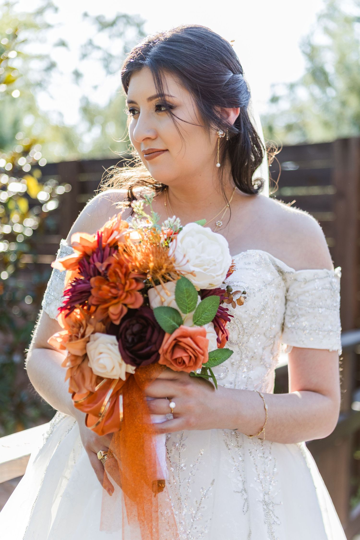 Close-up details of an autumn wedding bouquet with rich orange and deep burgundy blooms.