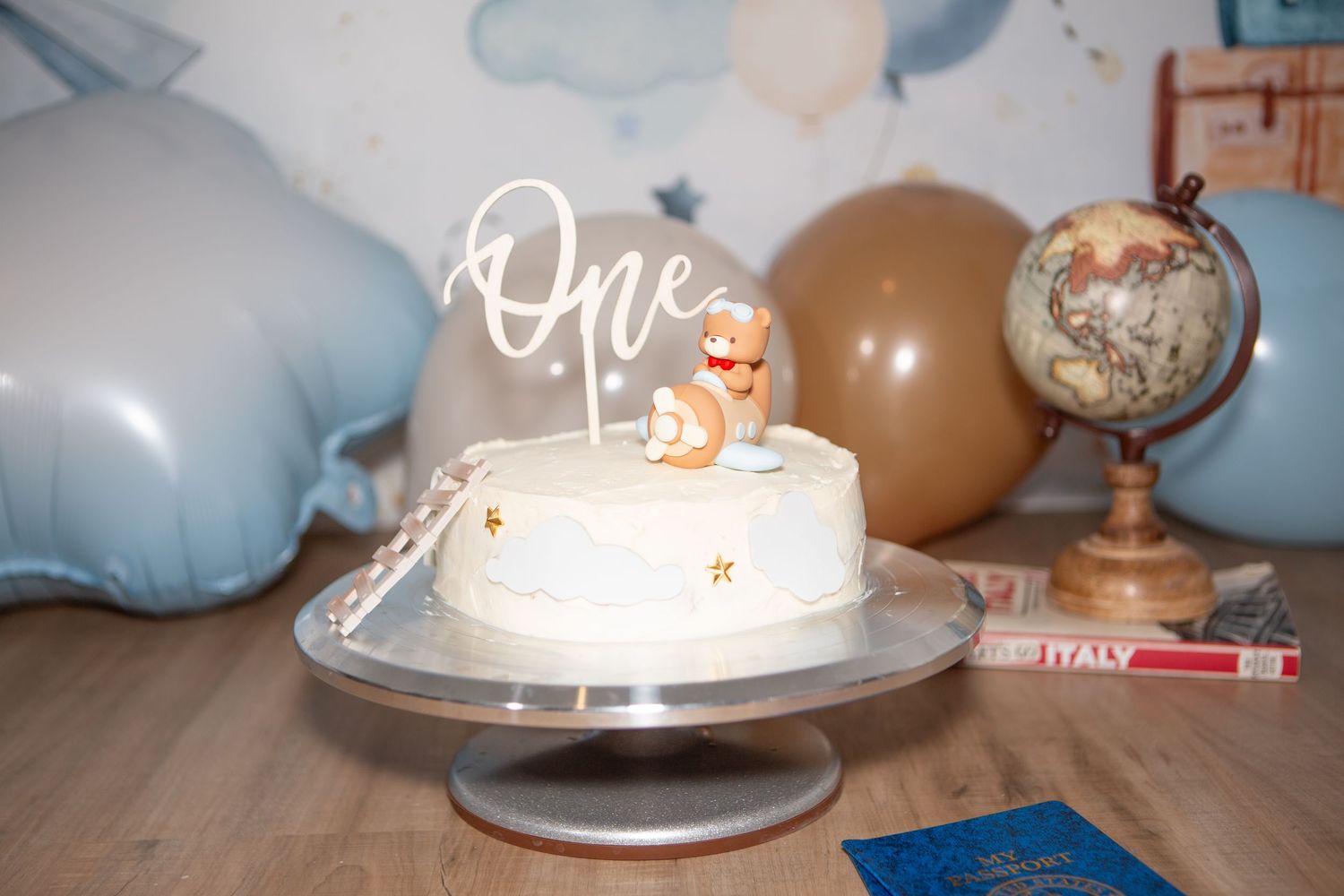 Birthday party decorations with globe, cake, and blue cloud motifs.