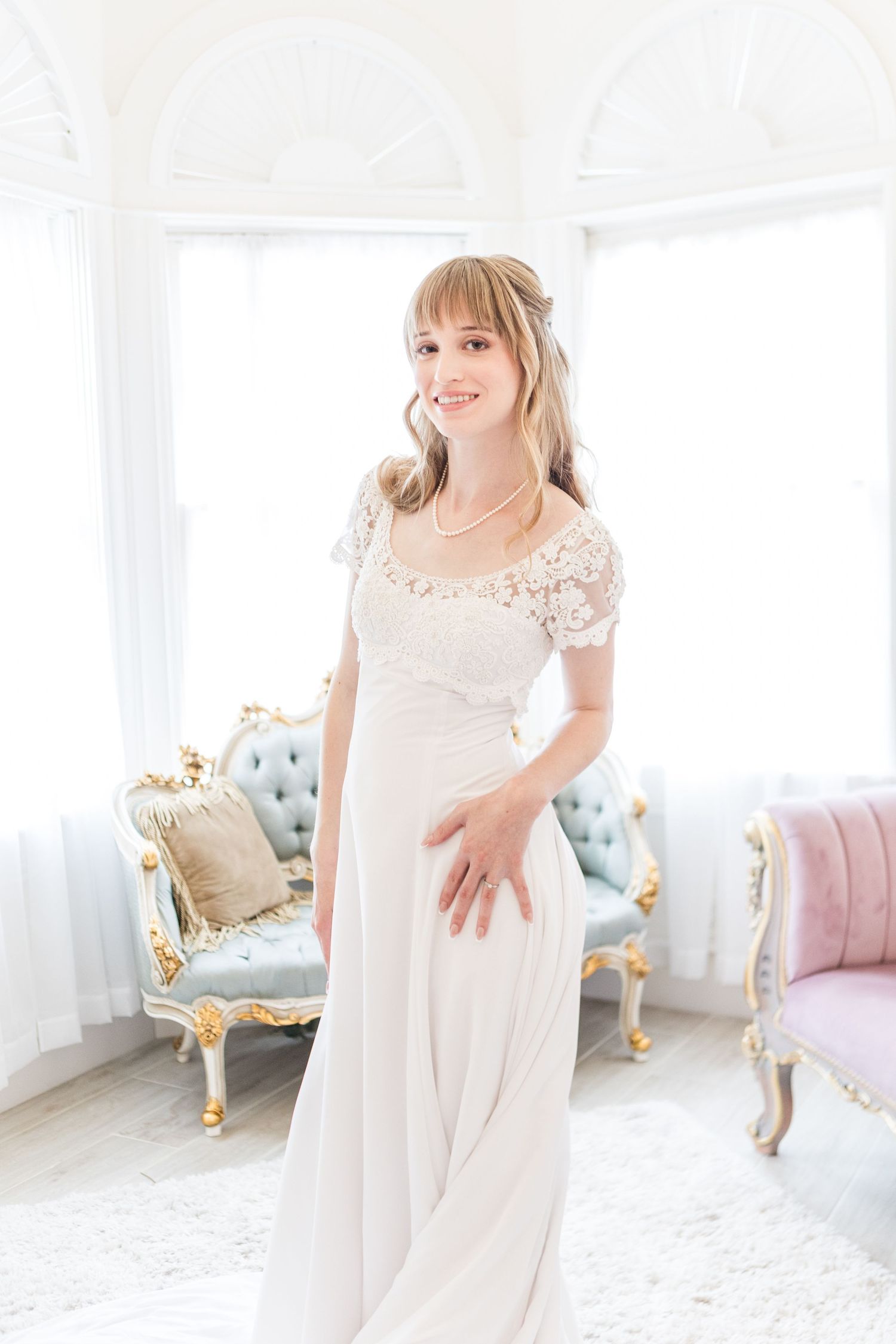 Light and airy bridal preparation room with ornate gold furniture and white decor.