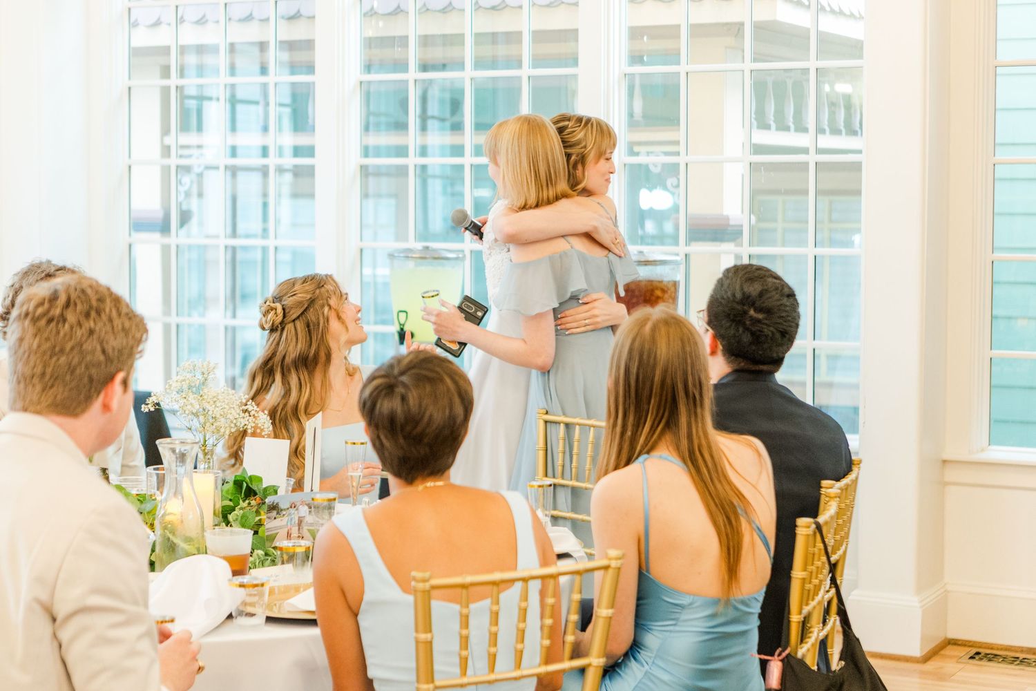 Wedding reception dining room filled with guests at round tables.