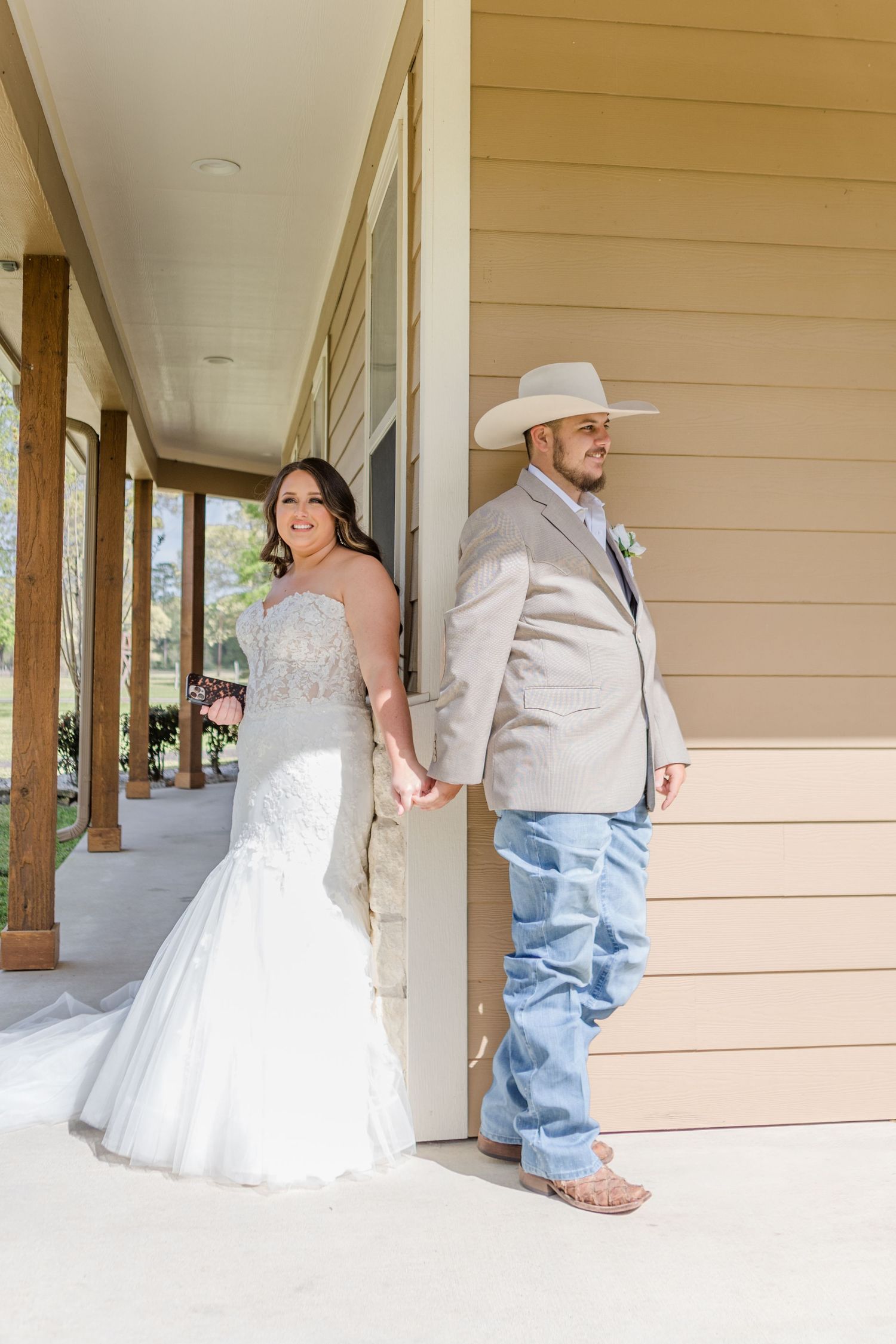 First look wedding photos on a covered porch with rustic country style elements.