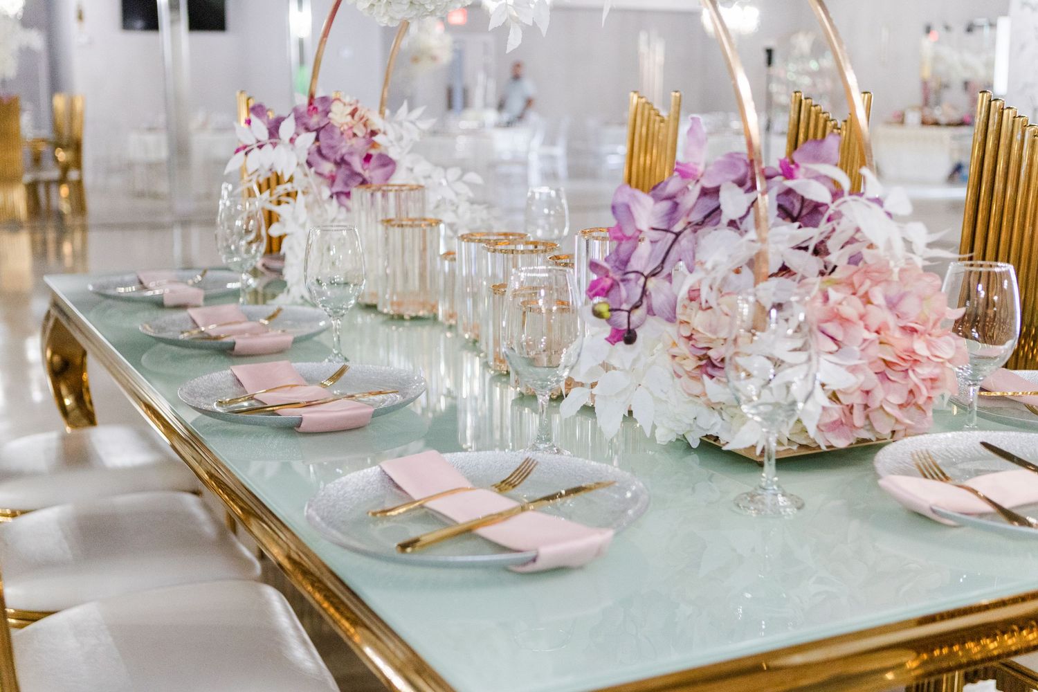 Luxury event space featuring gold and mint green table settings with crystal accents.