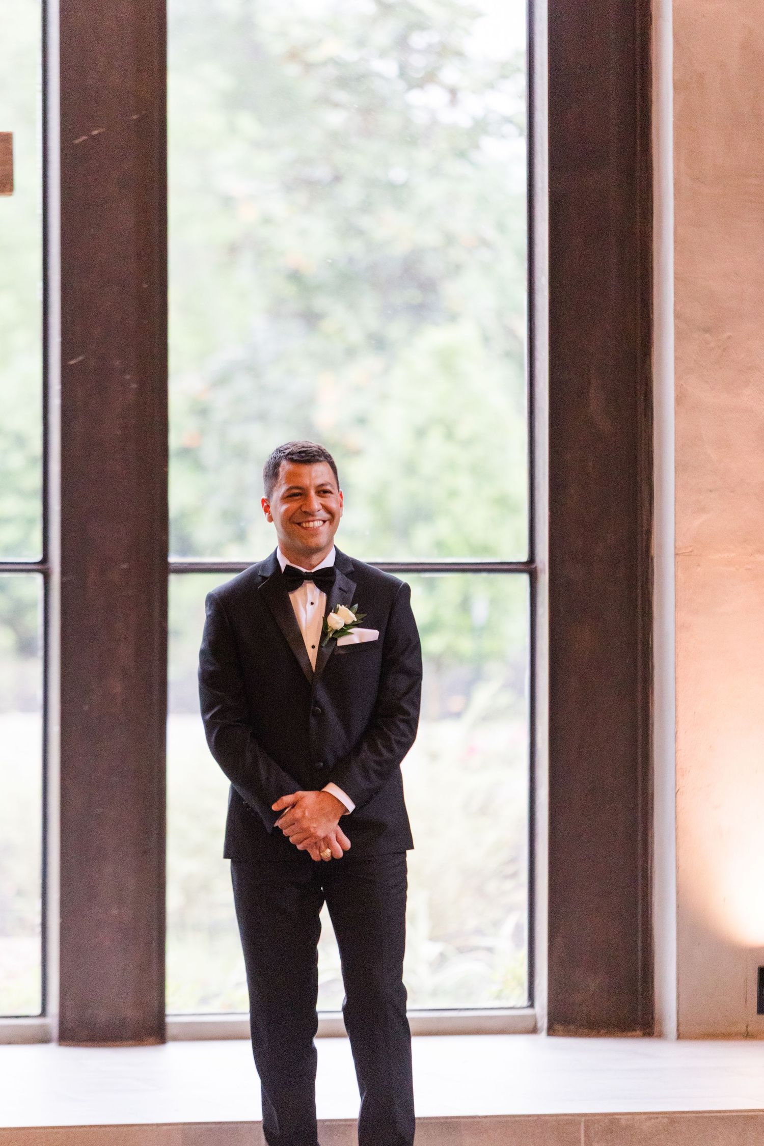 Wedding day emotions captured in front of bright windows with natural lighting.