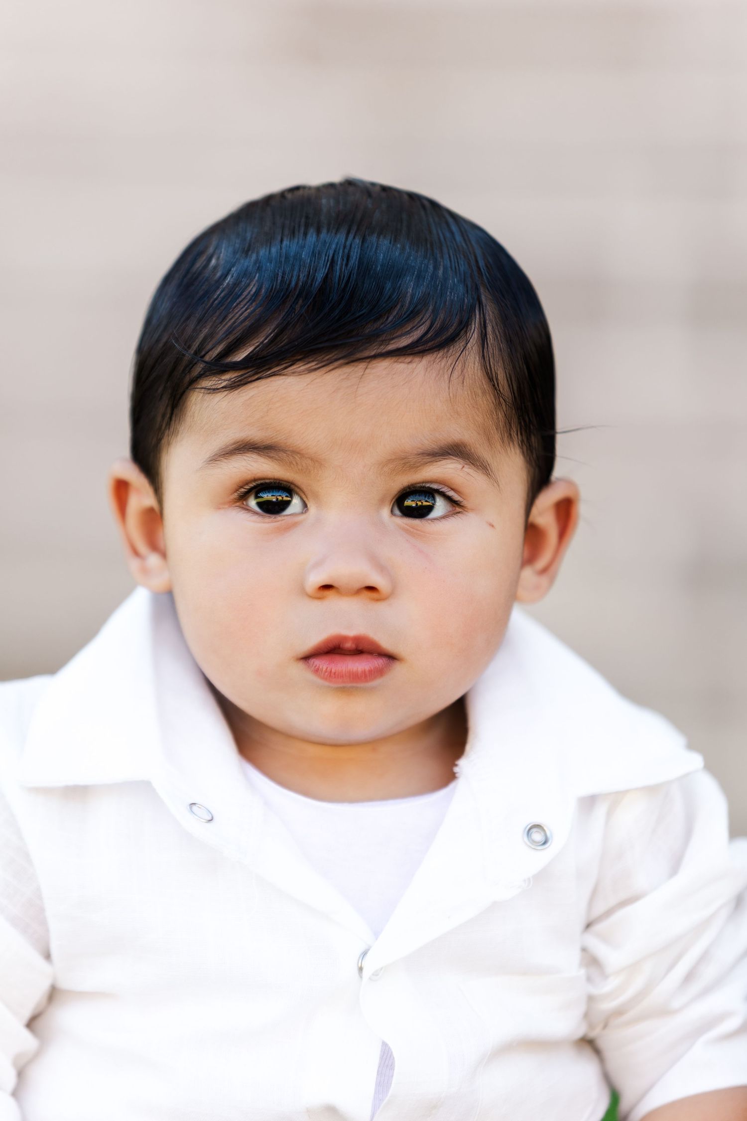 Close-up portrait shot against neutral background with soft lighting.