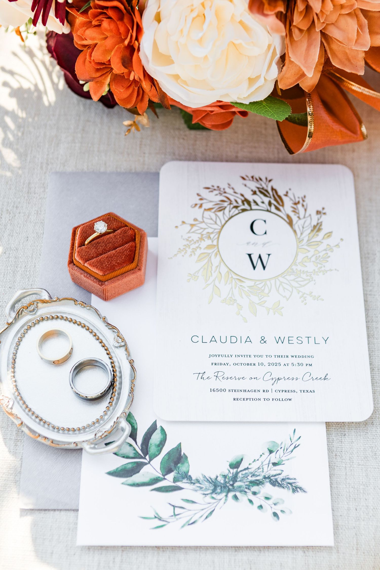 Elegant wedding invitation suite with orange flowers, floral wreath monogram design, and hexagonal copper details.