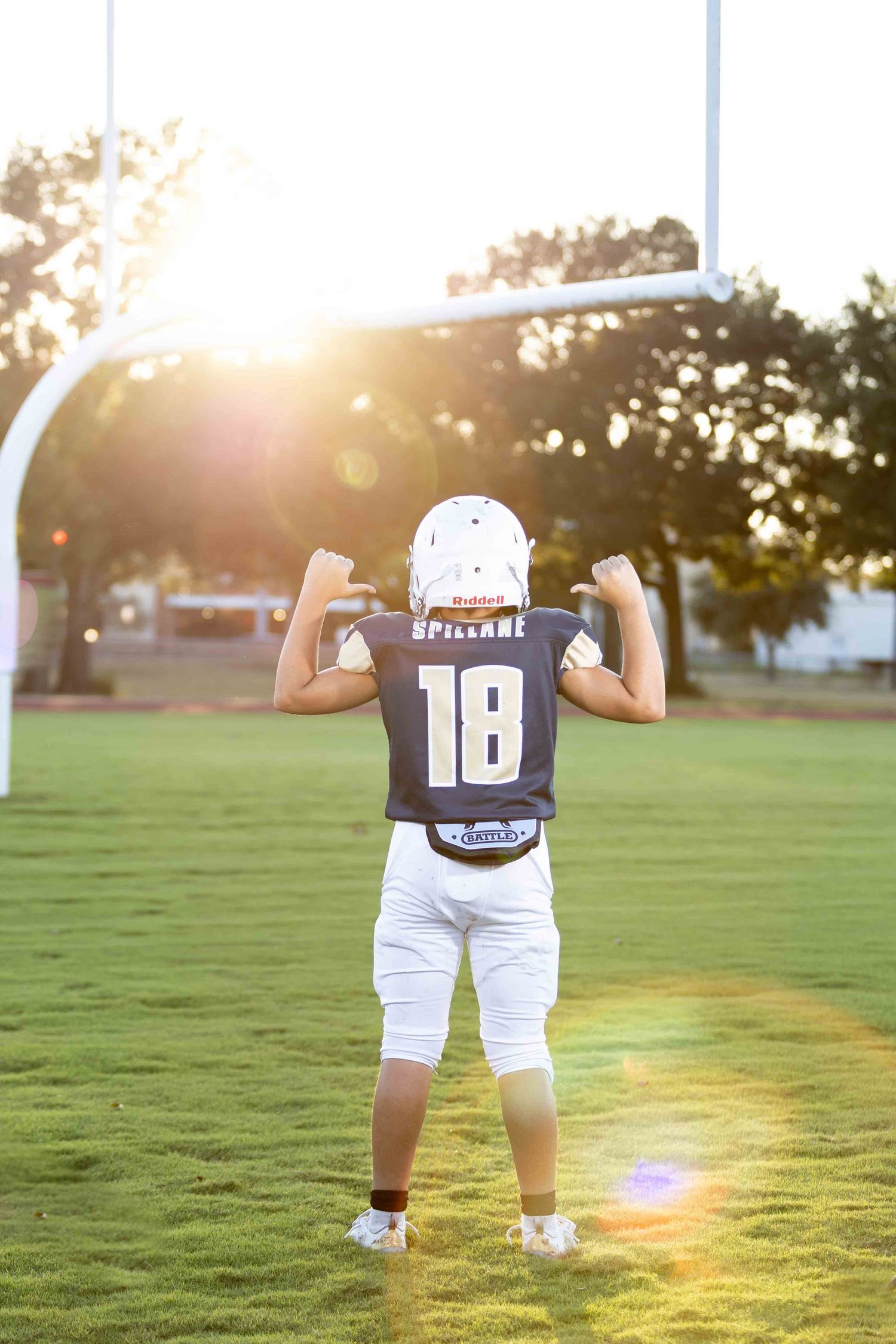 A sequence of photos showing a baby walking away in a sports jersey number 18 on a sunlit grassy field at sunset.