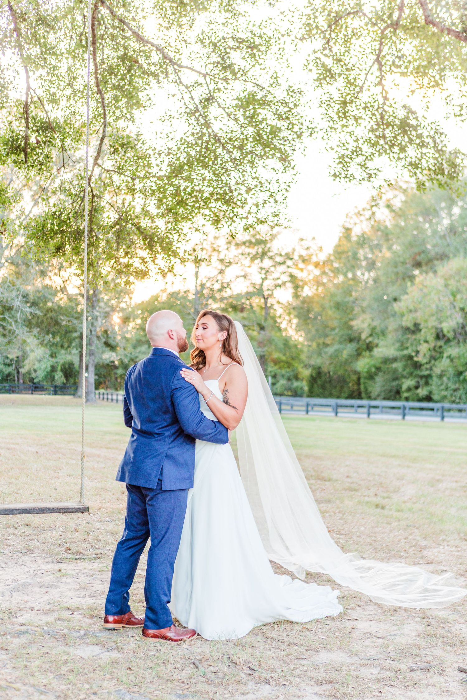 Wedding couple sharing a romantic moment on a rustic swing outdoors.