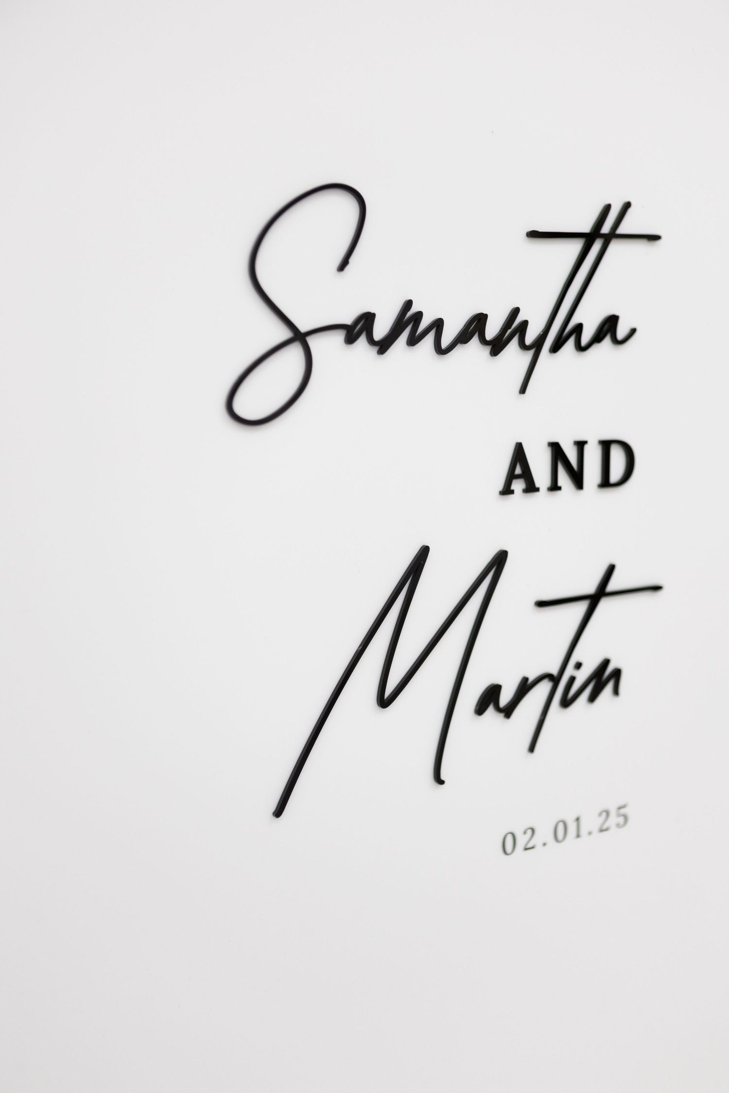 Elegant wedding monogram and date written in black script on white paper.