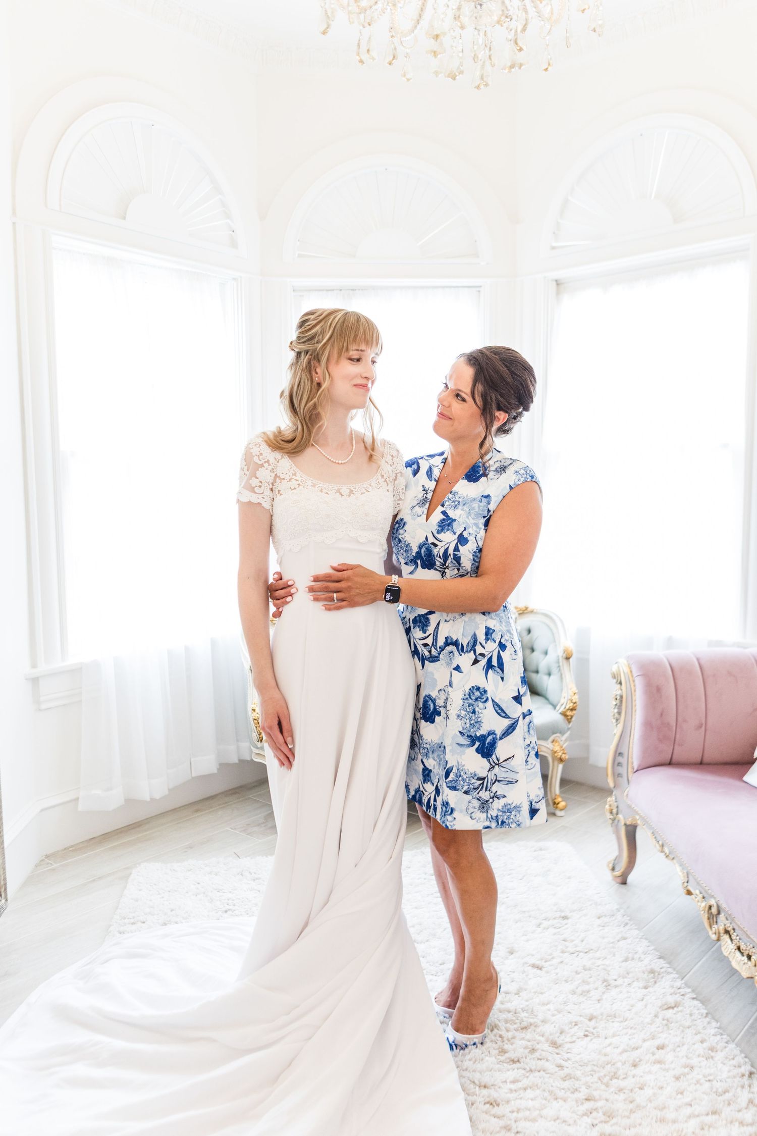 Elegant bridal preparation scene in a bright white room with vintage furniture.